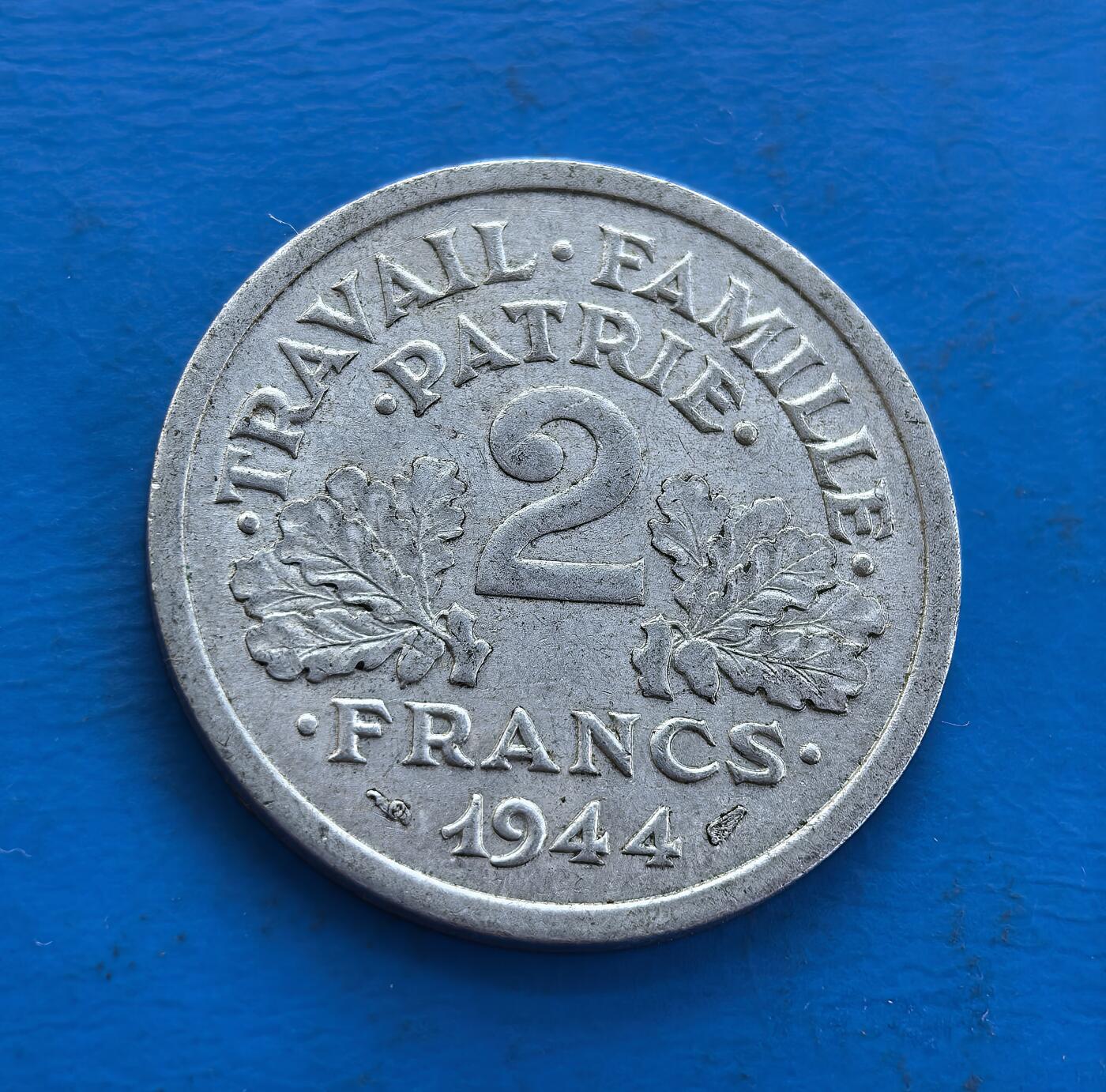 外国优质老铜币高银银币，周六九点倒数截拍，满百包邮，持续收拍 维希法国1944 年 2 法郎B版，诞生于二战法国被占期。正面斧与麦穗、背面 “工作・家庭・祖国”，凝萃维希政权符号。镍质包浆载战时痕，属特殊政权货币标本。解码法国二战分裂史，小众却藏时代矛盾，是研究战时政治、拓展收藏视野的独特标的，历史厚重与符号意趣交融 。