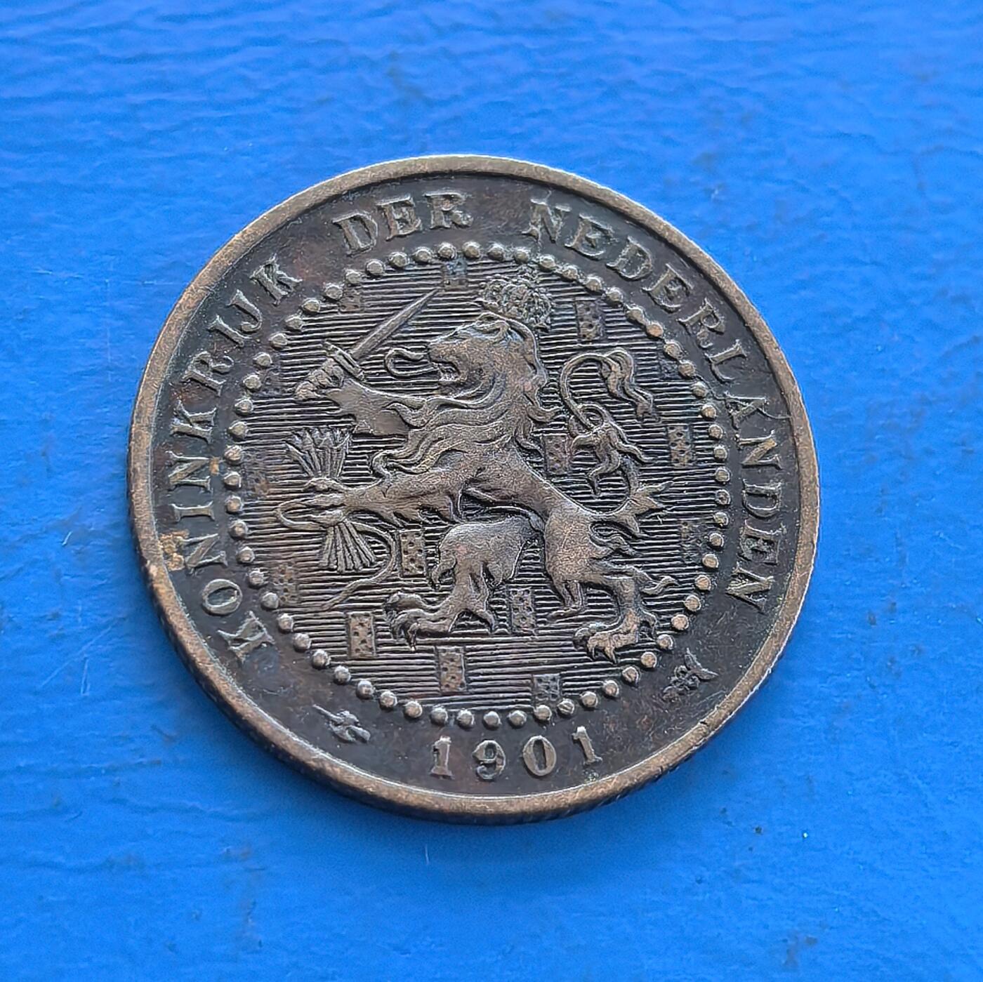 外国优质老铜币高银银币，周六九点倒数截拍，满百包邮，持续收拍 荷兰1901 年壹分，铸于威廉明娜女王统治期，见证荷兰王国时代。正面雄狮国徽展王室威严，背面花环围面值，青铜包浆载百年痕迹。属殖民流通币标本，设计融王权与自然元素，存世渐稀，是解码荷兰历史、欧币收藏入门的独特标的 。