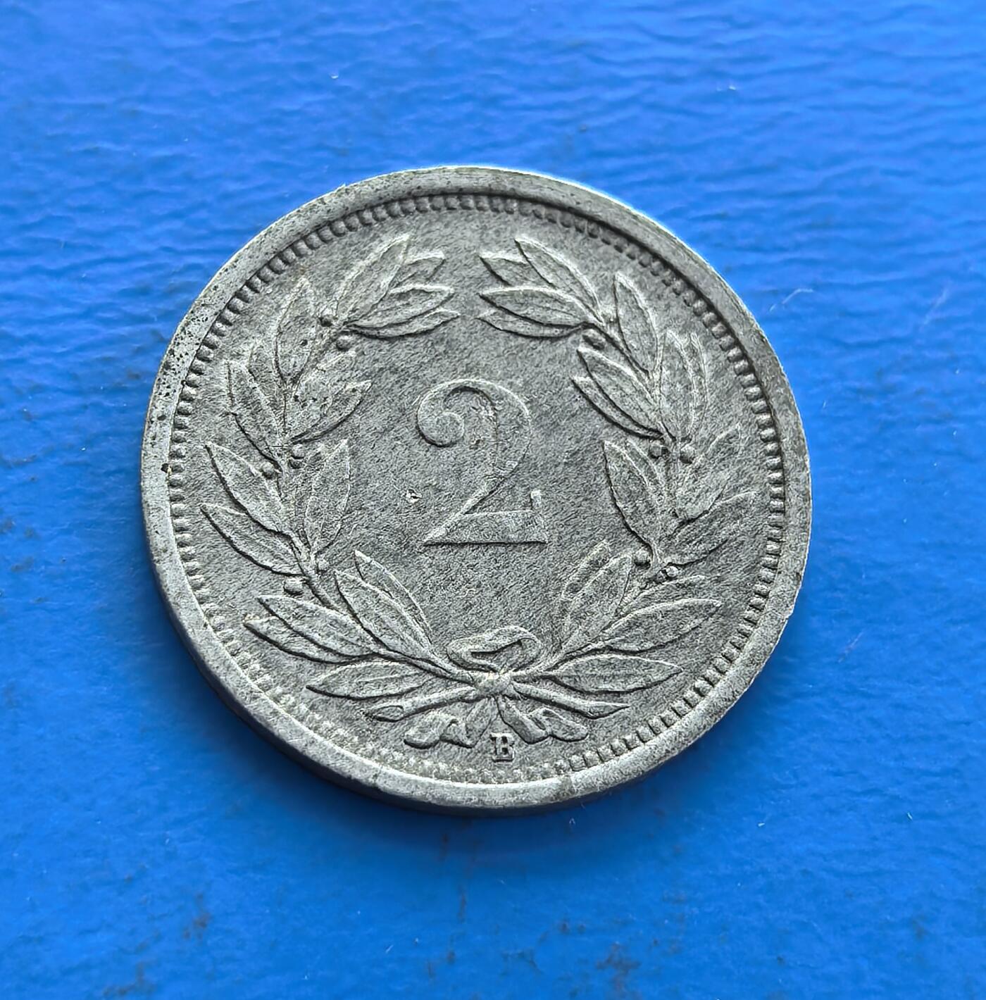 外国优质老铜币高银银币，周六九点倒数截拍，满百包邮，持续收拍 瑞士1945 年 2 分，诞生于二战终结时刻，中立国背景独特。正面国徽（十字盾、花环）与 “HELVETIA”（瑞士拉丁名）呼应，背面橄榄枝环饰面值，凝萃和平寓意。铜镍包浆载战后余韵，设计简约却藏时代厚重，见证瑞士中立史与二战落幕，是解码欧洲战后脉络、收藏和平符号的独特标的 。