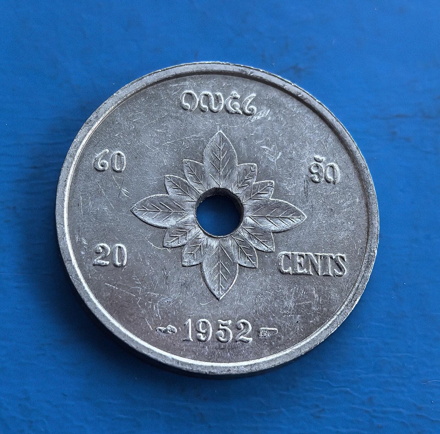 外国优质老铜币高银银币，周六九点倒数截拍，满百包邮，持续收拍 老挝王国1952年20 分，独特穿孔设计。正面双象拱卫佛塔，融合宗教与王室符号；背面花叶纹呼应民俗。包浆自然，见证老挝君主制阶段。属东南亚小众币，承载中南半岛文化印记，稀缺异域属性，是收藏拓展视野、解码老挝历史的独特标的 。
