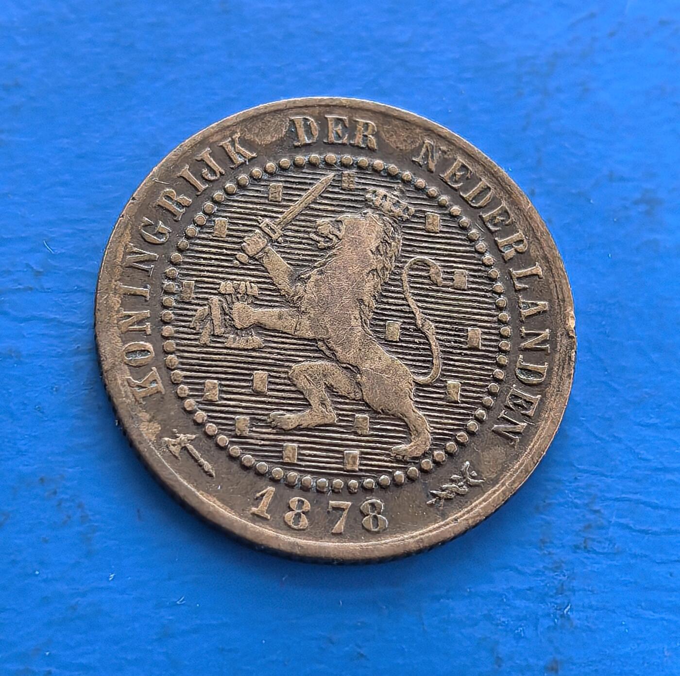 外国优质老铜币高银银币，周六九点倒数截拍，满百包邮，持续收拍 荷兰1878 年1 分铜币，铸于威廉三世统治期，见证王国近代历程。正面雄狮国徽（持剑握箭袋，凝武力与商贸符号），背面花环围 “1 CENT”，青铜包浆载百年痕迹。属殖民流通币标本，设计融王权元素，存世渐稀，是解码荷兰历史、欧币收藏入门的独特标的 。