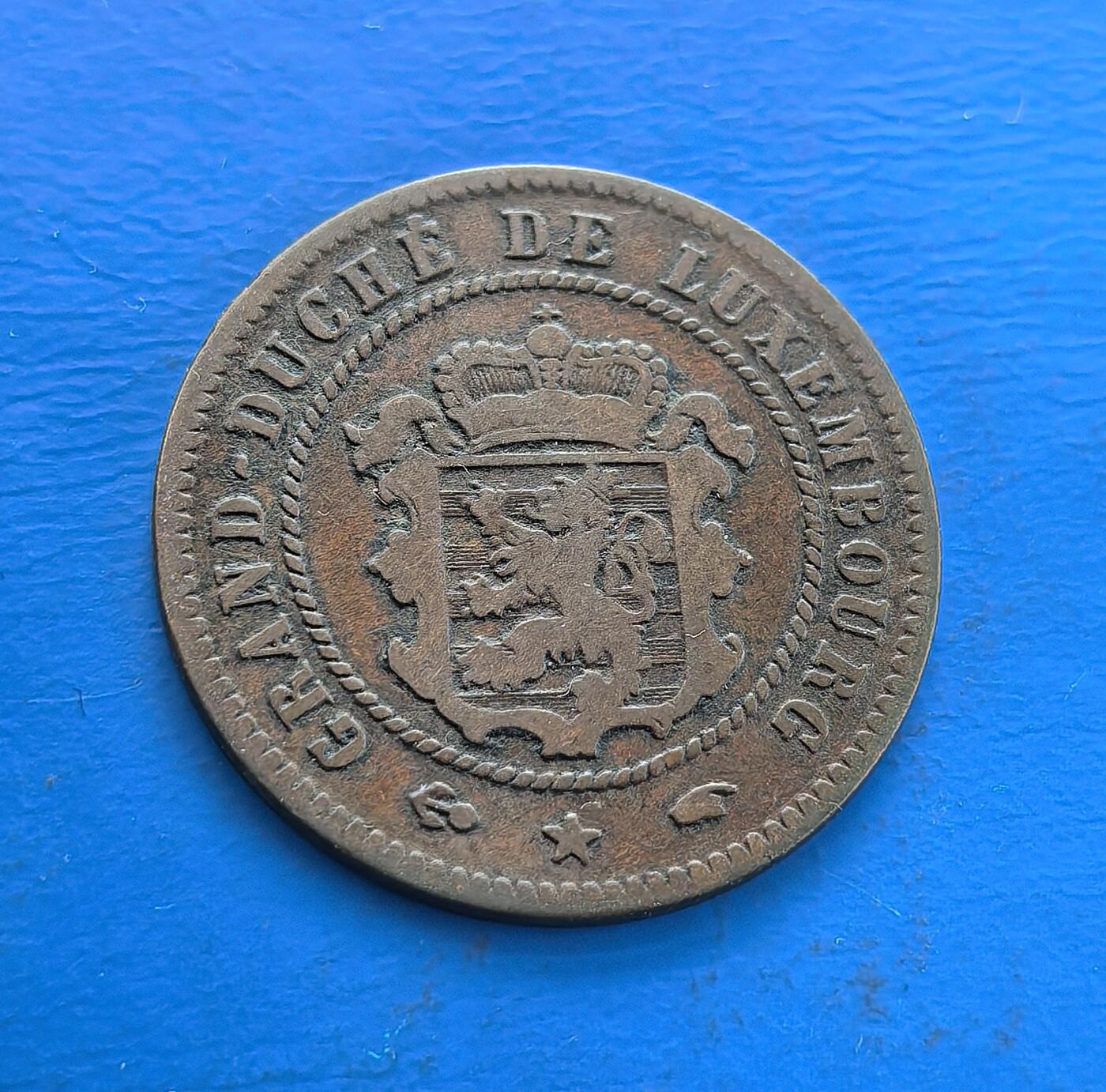 外国优质老铜币高银银币，周六九点倒数截拍，满百包邮，持续收拍 卢森堡大公国1860 年 5 分铜币，正面花环寄繁荣愿景，背面纹章（雄狮、王冠）彰王室威严。铜质包浆凝百年岁月，存世因年代流逝渐稀。见证卢森堡君主制货币脉络，融纹章艺术与欧陆小国历史，是解码其早期发展与货币美学的珍稀标本 。