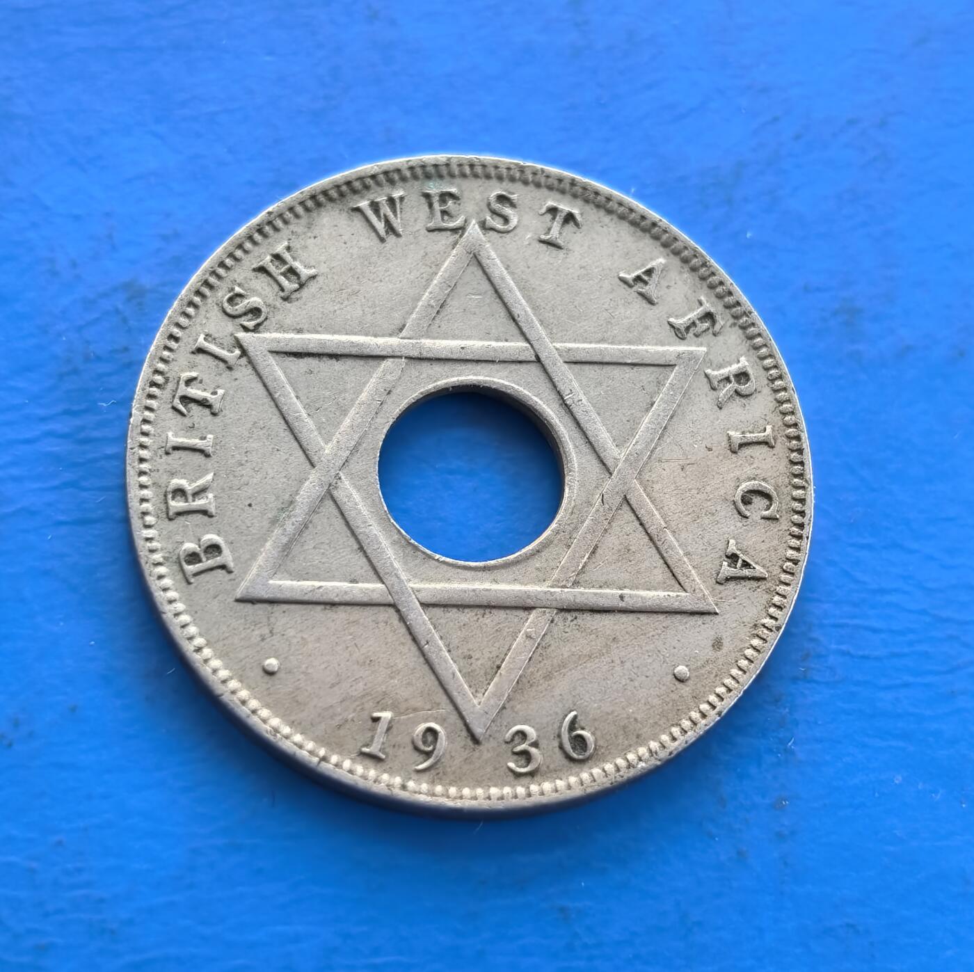 外国优质老铜币高银银币，周六九点倒数截拍，满百包邮，持续收拍 英属西非1936 年半便士H版，诞生于爱德华八世短暂统治（同年退位），见证王室危机与殖民史。中孔设计，正面镌王室铭文及阿拉伯文，背面六芒星分割纪年，融合多元符号。因君主在位极短，成 “过渡政权” 货币标本，历史厚重 + 独特形制，解码英殖民与王室跌宕，是小众收藏的时代切片 。