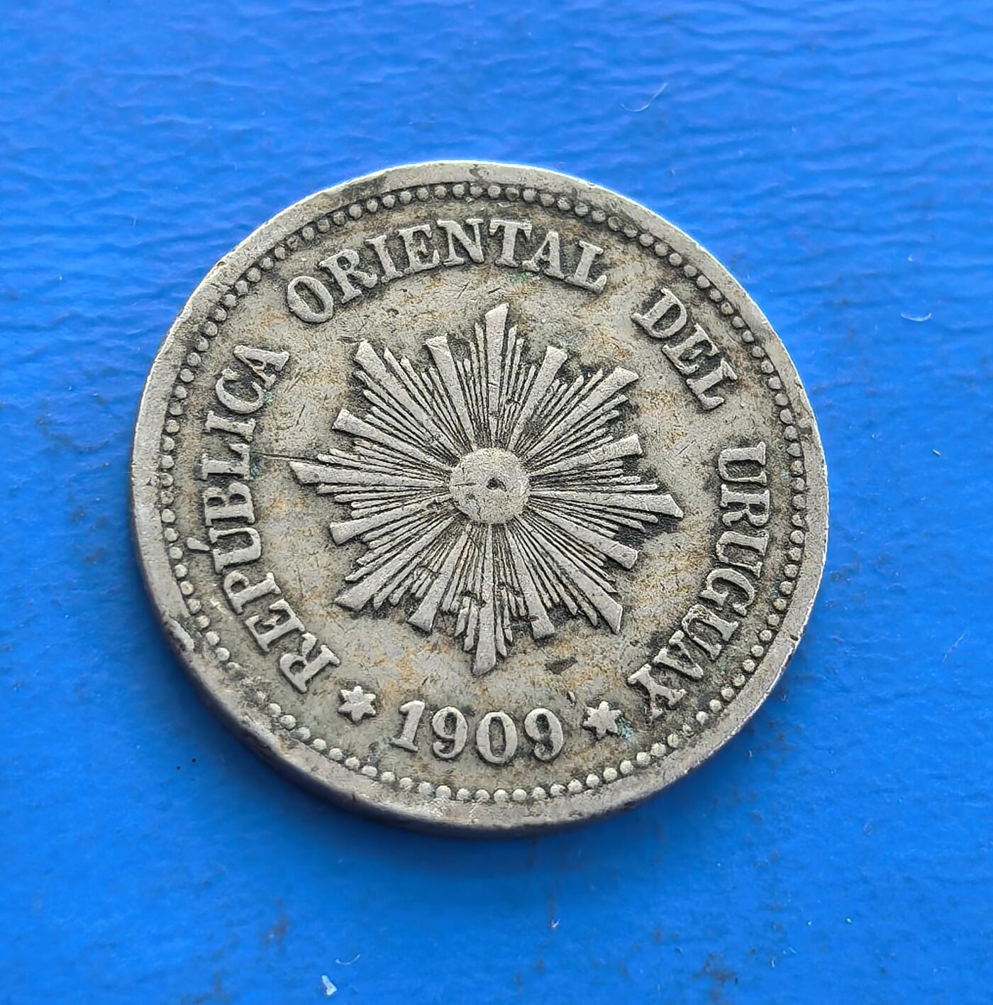 外国优质老铜币高银银币，周六九点倒数截拍，满百包邮，持续收拍 乌拉圭 1909 年2 分，见证南美共和初创期。背面放射纹象征独立精神，正面花环寄和平愿景，设计融地域符号与时代寓意。铜镍包浆载百年痕迹，南美小众存世渐稀。解码乌拉圭建国脉络，藏拉美共和史意趣，是触摸异域货币文化的独特标本 。