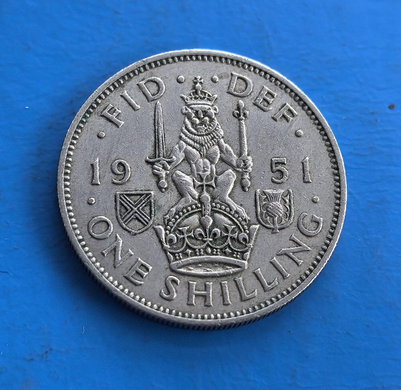 外国优质老铜币高银银币，周六九点倒数截拍，满百包邮，持续收拍 英国1951 年1先令，正面乔治六世肖像，背面英格兰雄狮踞皇冠，铭刻王室符号。属战后流通币，铜镍材质包浆自然，见证英帝国币制脉络。传统纹章设计 + 特定历史节点，是钱币收藏触摸王室历史与时代记忆的独特标的，亦适工艺创作 。