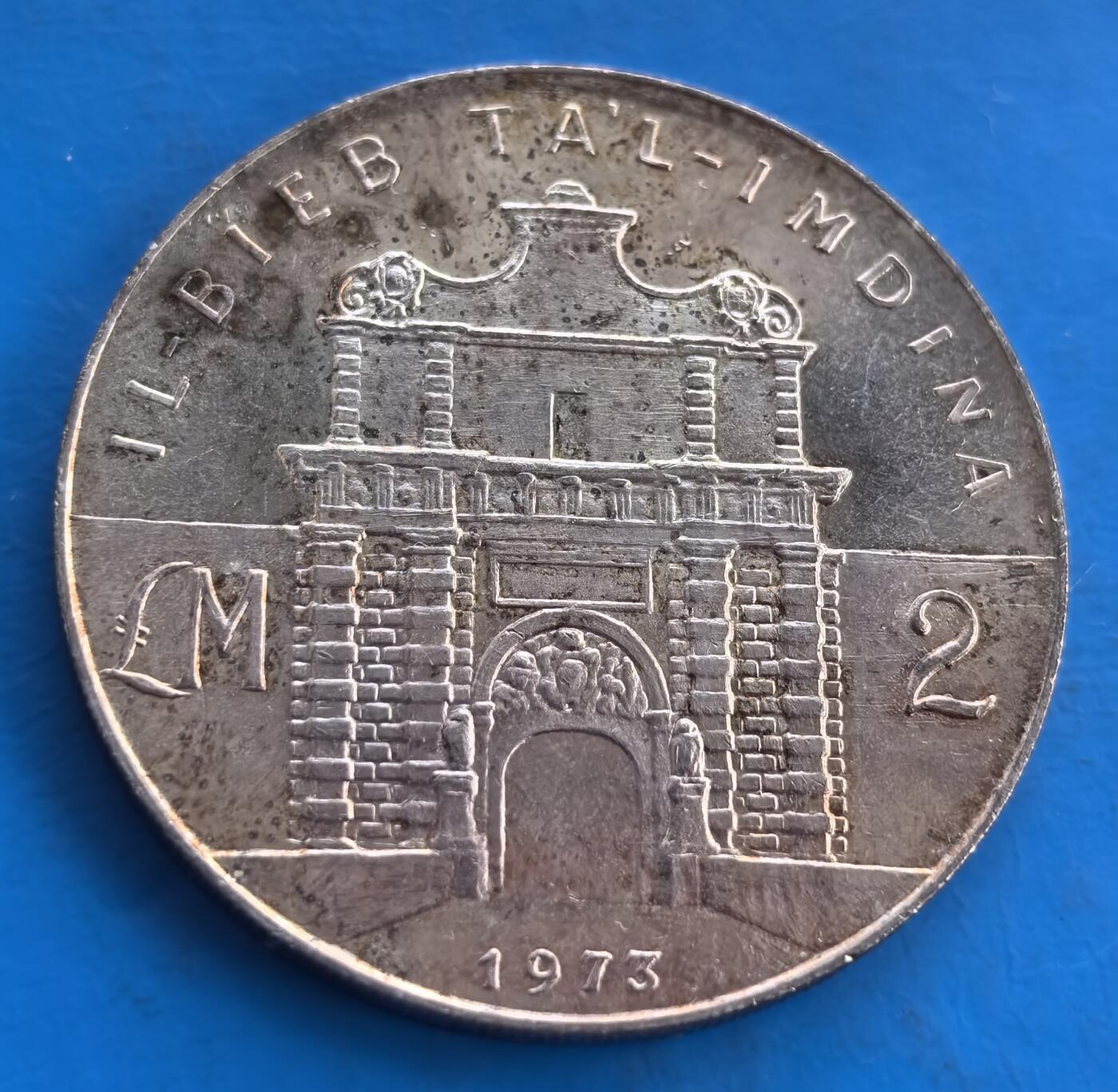外国优质老铜币高银银币，周六九点倒数截拍，满百包邮，持续收拍 马耳他 1973 年2 里拉大银币，正面镌国徽（双海马护盾、城堡顶，配 “勇气与坚韧” 铭文），背面刻姆迪纳古城门，尽显地中海岛国建筑与纹章艺术。小众国家钱币，填补收藏版图空白，是挖掘地中海货币文化、品鉴历史建筑的优质藏品，历史底蕴与艺术价值交融 。