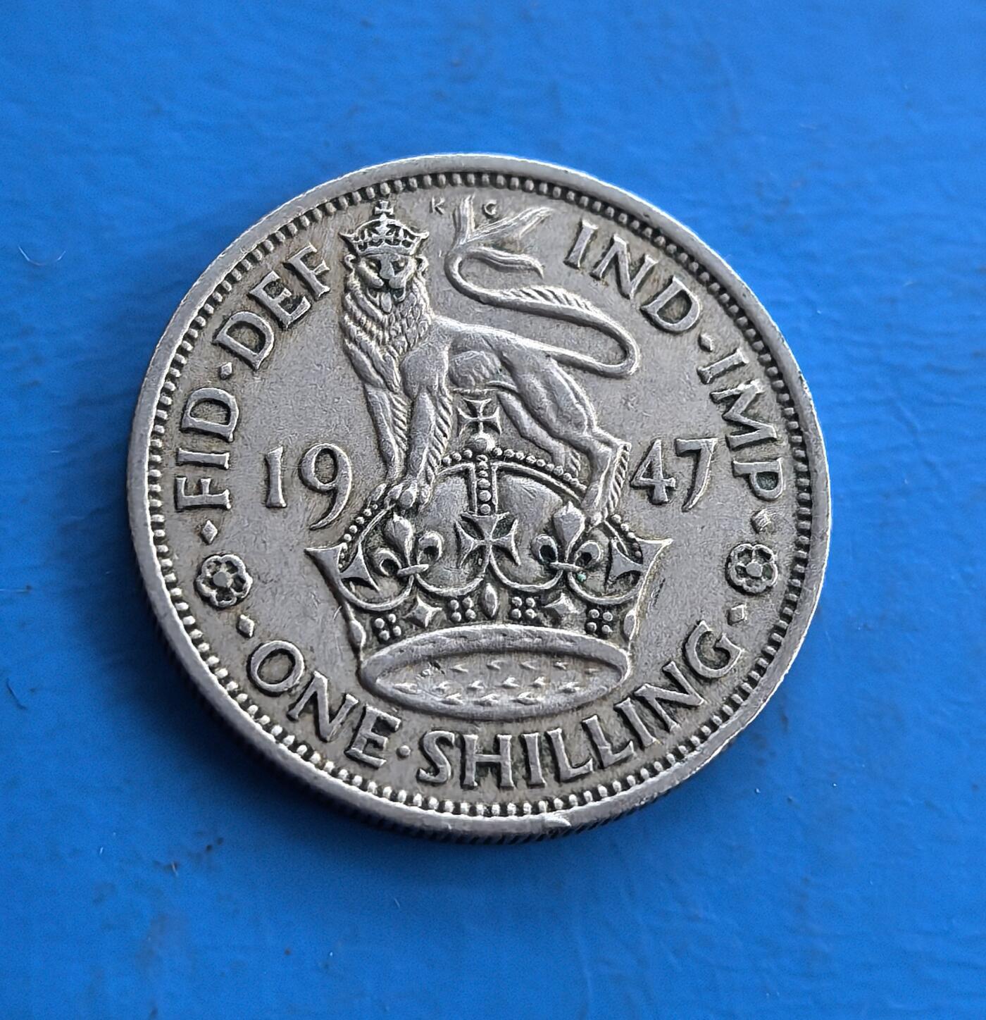 外国优质老铜币高银银币，周六九点倒数截拍，满百包邮，持续收拍 英国1947 年1先令，正值英帝国殖民体系瓦解前夜（印度同年独立），背面 “IND・IMP”（印度皇帝）是殖民符号的最后印记。正面乔治六世像，背面雄狮踞皇冠，皇家纹章经典。铜镍包浆古朴，承载帝国兴衰脉络，是解码殖民时代终结的收藏标的，历史厚重与设计美感兼具 。