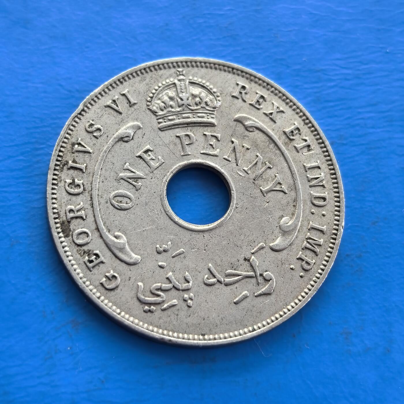 外国优质老铜币高银银币，周六九点倒数截拍，满百包邮，持续收拍 英属西非1942 年 1 便士，中孔设计别致。正面镌乔治六世王冠、王室铭文与阿拉伯文，背面六芒星环绕，融合殖民与多元文化符号。诞生于二战关键期，见证英属西非历史，铜镍包浆凝岁月痕，属殖民币稀缺标本，解码战时脉络，收藏兼具故事性与设计价值 。