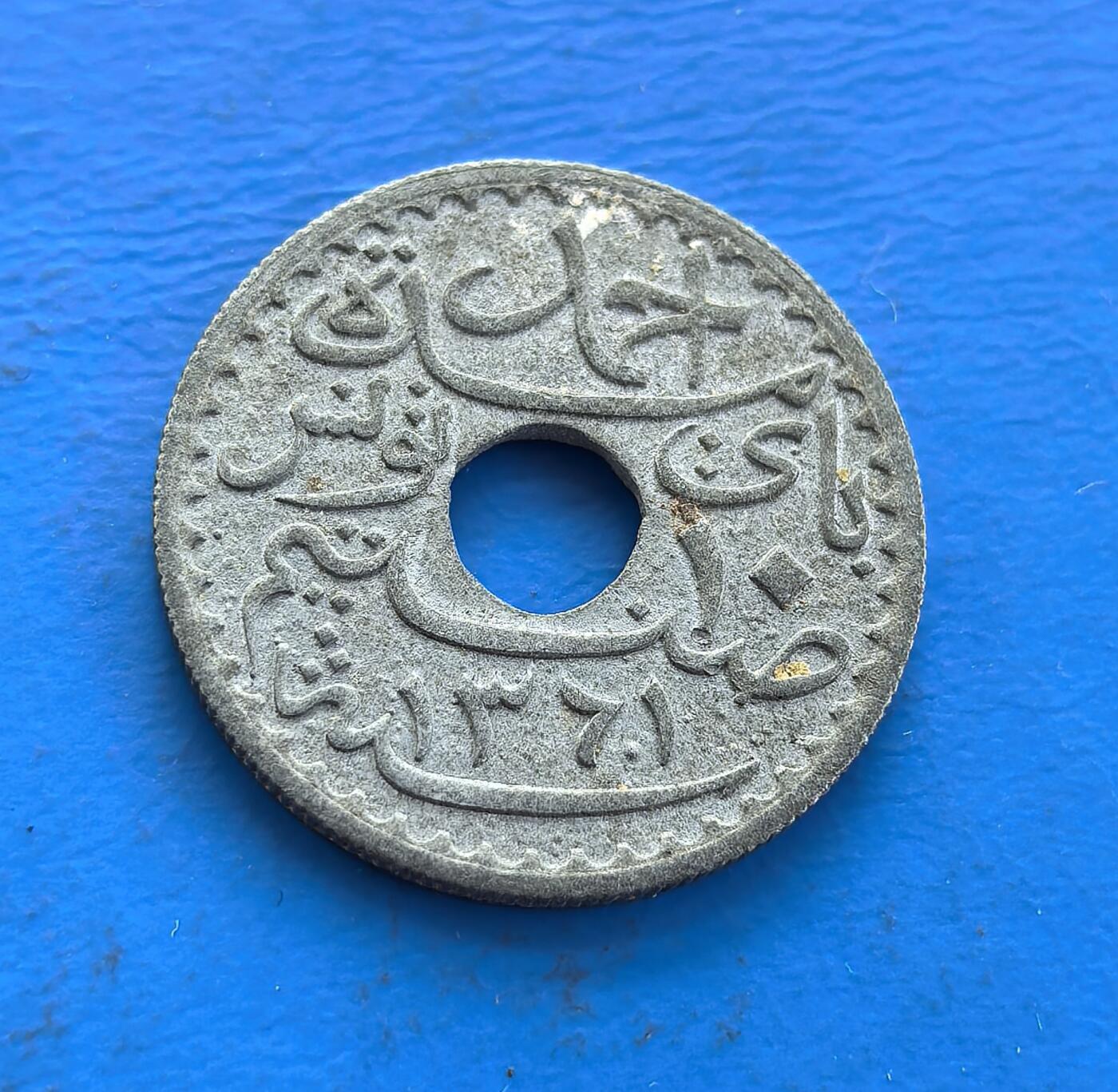 外国优质老铜币高银银币，周六九点倒数截拍，满百包邮，持续收拍 法属突尼斯 1942 年10 分圆孔币，诞生于二战烽火，见证殖民统治与文化交融。正面法语、背面阿拉伯文，圆孔形制独特。铜镍包浆载岁月痕迹，存世因战乱、政权更迭渐稀。属北非殖民币标本，解码法突文化碰撞，藏战争与殖民双重脉络，是触摸异域殖民史的独特标的 。