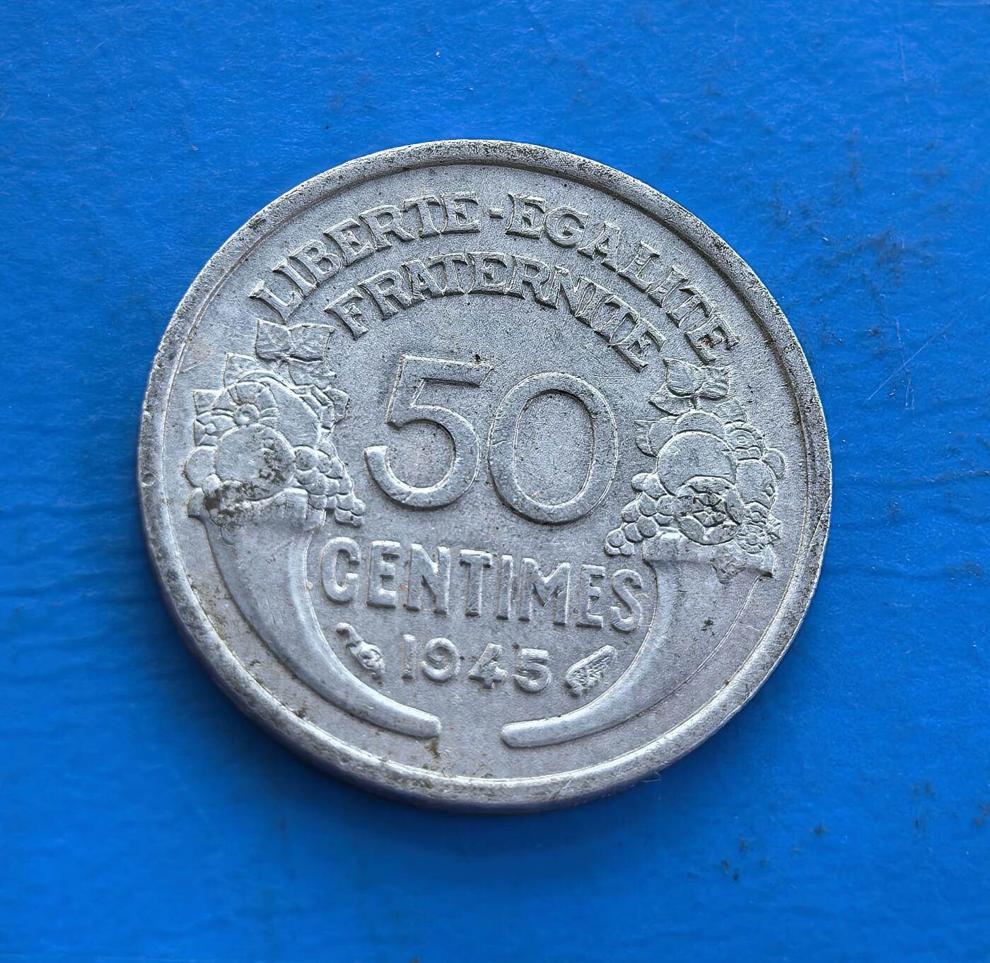 外国优质老铜币高银银币，周六九点倒数截拍，满百包邮，持续收拍 法国 1945 年50 分，诞生于二战胜利时刻，见证法兰西从废墟复苏。正面玛丽安娜诠释共和精神，背面 “自由・平等・博爱” 锚定启蒙根基，葡萄纹饰暗喻战后生机。镍质包浆凝岁月痕，作为战后首年货币，解码历史转折，收藏兼具时代纪念与文化传承，是触摸法兰西精神脉络的独特标本 。