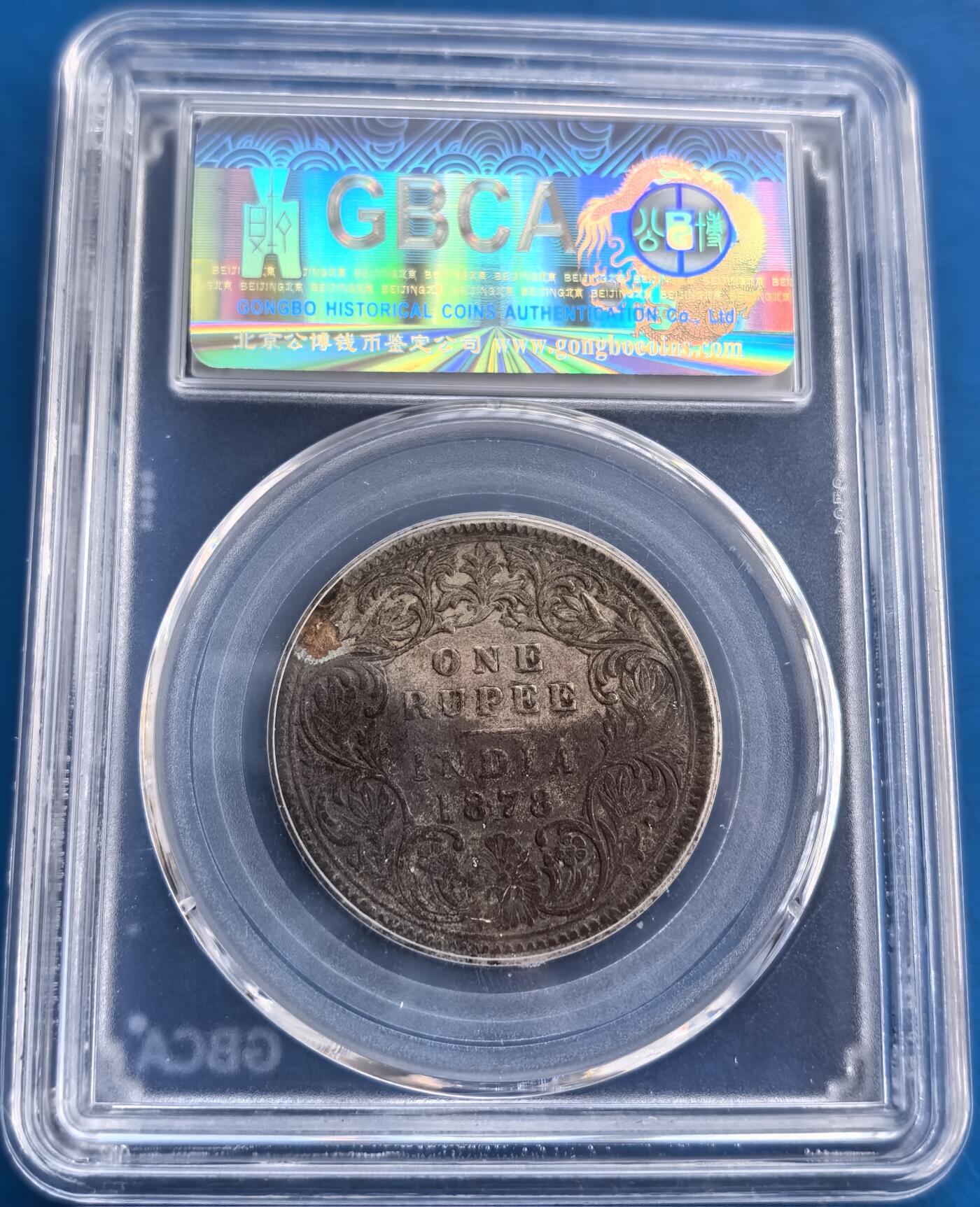 外国优质老铜币高银银币，周六九点倒数截拍，满百包邮，持续收拍 英属印度 1878 年1 卢比银币，公博 GBCA 权威认证保真。正面刻维多利亚女王像，背面饰精美花纹，铭记英属印度殖民史。虽经百年，包浆厚重却细节犹存，30.5mm 直径、11.6g 银质，工艺精湛。兼具历史厚重感与收藏属性，是钱币藏家追溯殖民货币文化、拓展藏品体系的优质之选，投资与研究价值俱佳 。