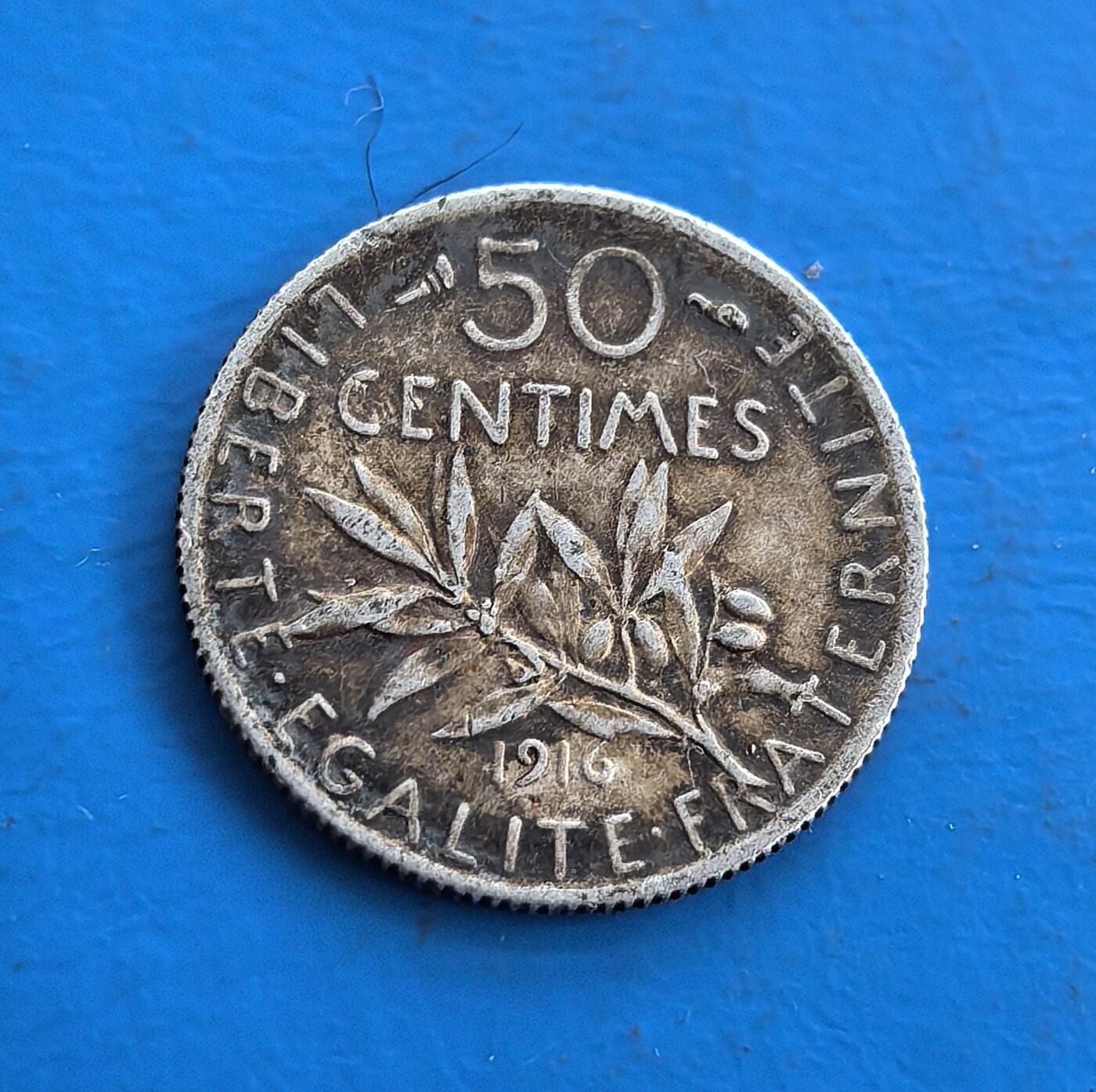 外国优质老铜币高银银币，周六九点倒数截拍，满百包邮，持续收拍 法国1916 年50 生丁银币，正值一战关键期，承载特殊历史记忆。正面 “播种女神” 象征共和，背面橄榄枝暗喻和平，与战争背景形成强烈呼应 。币面铭刻 “自由、平等、博爱”，银币包浆古朴，将法式共和精神与艺术设计融合，是历史与收藏价值兼具的稀缺标的。