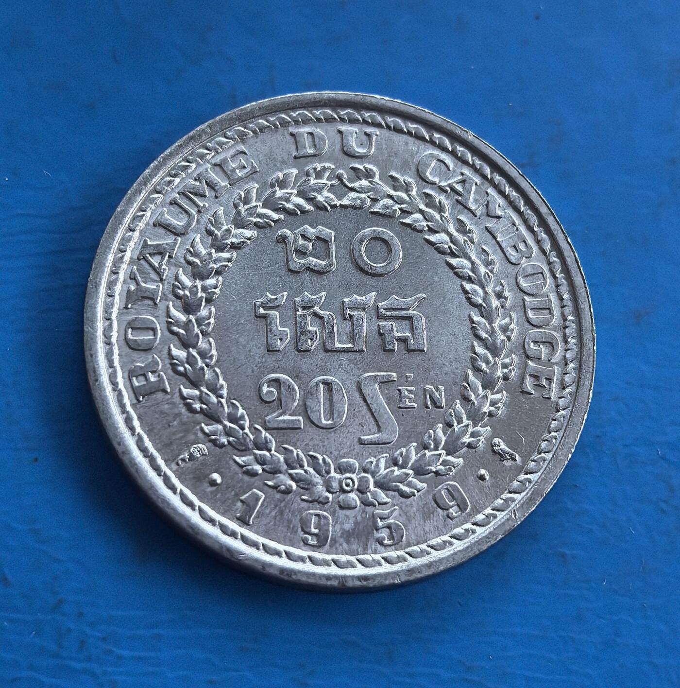 外国优质老铜币高银银币，周六九点倒数截拍，满百包邮，持续收拍 柬埔寨王国1959 年 20 分，见证西哈努克执政期君主制阶段。正面法语王室铭文配花环，背面高棉祭台融宗教符号，浮雕细腻。包浆载岁月痕迹，聚合殖民遗风与高棉文化，属东南亚钱币收藏稀缺标的，解码柬埔寨历史密码 。