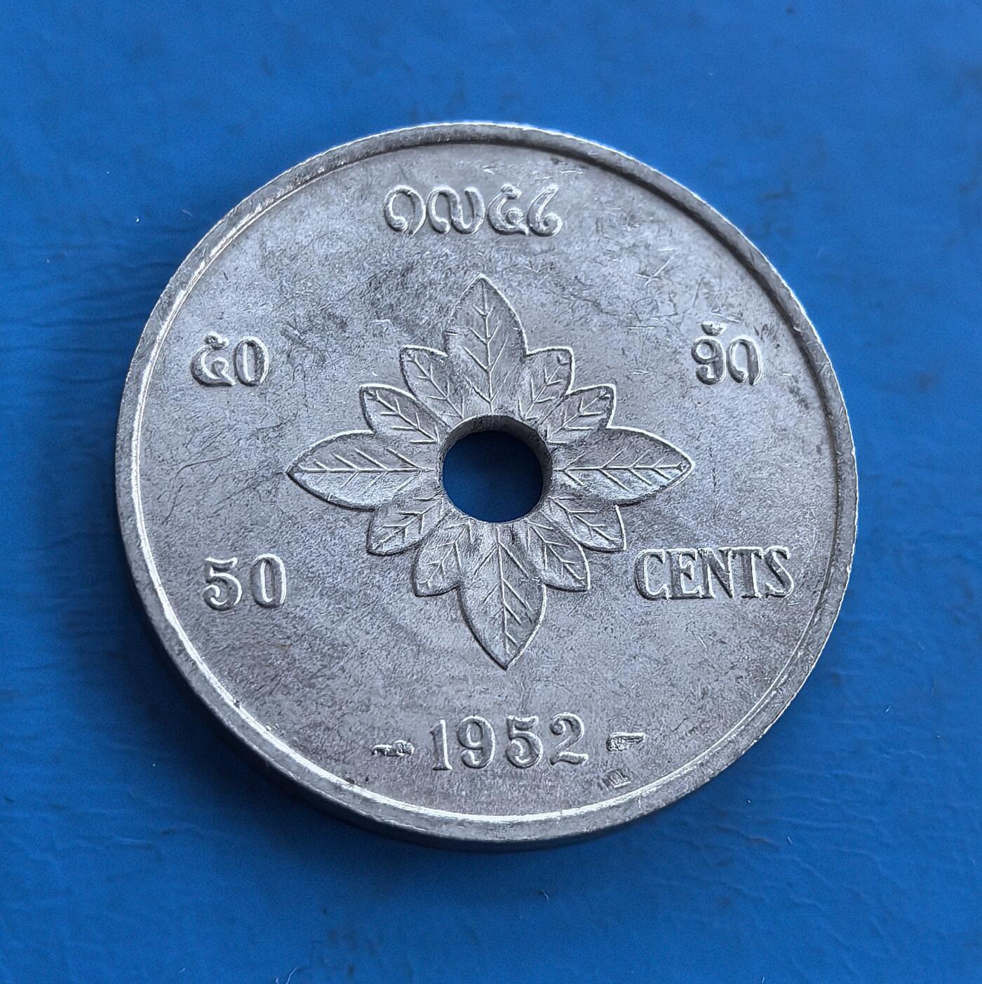 外国优质老铜币高银银币，周六九点倒数截拍，满百包邮，持续收拍 老挝王国1952年50 分，中孔设计独特。正面饰王室祭台符号，背面花叶纹呼应民俗，铝质包浆蕴岁月痕迹。见证君主制阶段，融合宗教与殖民文化，属东南亚小众币，承载地域历史密码，为钱币收藏拓展视野、解码老挝过往的独特标的 。