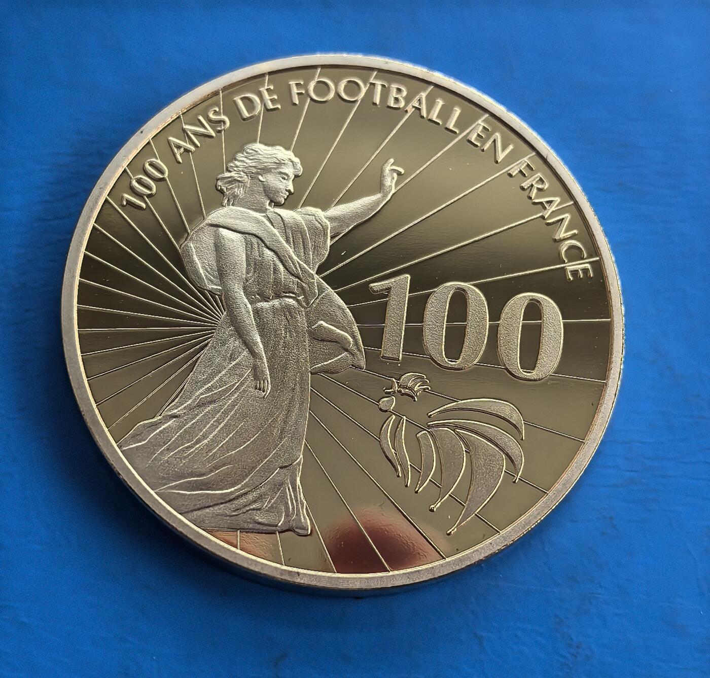 外国优质老铜币高银银币，周六九点倒数截拍，满百包邮，持续收拍 法国足球百年纪念章，直径40mm，26克，正面融合自由女神、高卢雄鸡等法式符号，背面聚焦 1976 捷欧杯经典瞬间。精制工艺刻画细腻，串联法国足球百年史与欧洲杯传奇，承载体育文化记忆，是球迷收藏跨界题材的优质标的，历史故事与艺术设计交融，稀缺性与纪念意义兼具 。