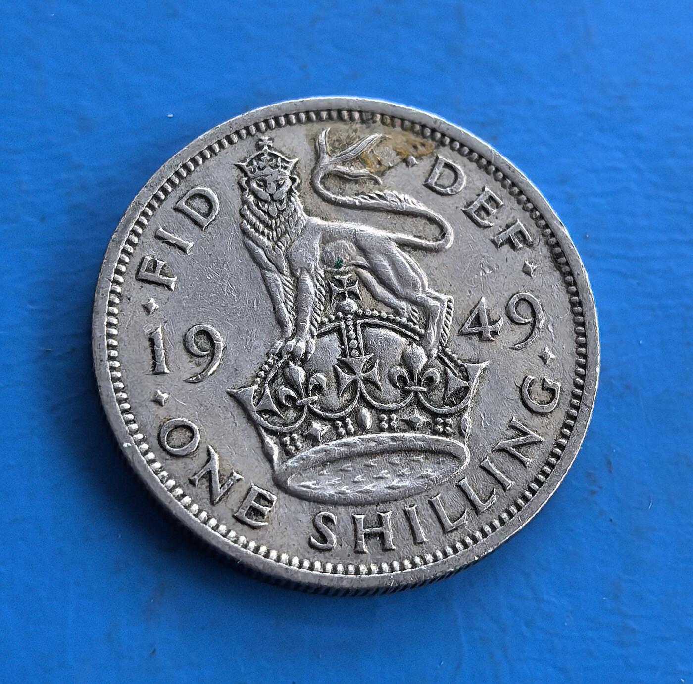 外国优质老铜币高银银币，周六九点倒数截拍，满百包邮，持续收拍 英国1949 年1先令，正面为乔治六世肖像，背面英格兰站狮踞皇冠，铭文承载王室符号。属战后流通币，铜镍材质留存岁月包浆，见证英帝国币制脉络。皇家纹章设计 + 特定历史节点，是钱币收藏触摸英王室历史与殖民时代的独特标的 。