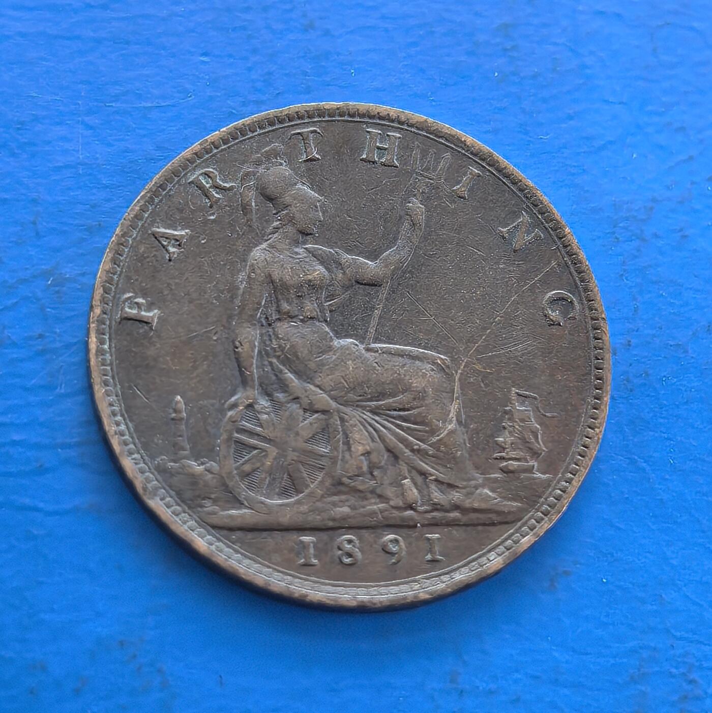 外国优质老铜币高银银币，周六九点倒数截拍，满百包邮，持续收拍 英国1891 年 1 法新铜币，铸于维多利亚帝国鼎盛期。正面女王肖像，背面不列颠尼亚坐像（持矛、轮盘，衬灯塔、帆船，凝萃海洋霸权符号）。铜质包浆载百年痕迹，见证殖民巅峰，属英国古典铜币标本，设计融王权与帝国意象，存世渐稀，解码 19 世纪英帝国脉络，收藏兼具历史厚重与艺术意趣 。