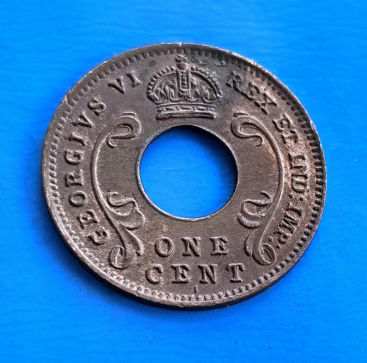 外国优质老铜币高银银币，周六九点倒数截拍，满百包邮，持续收拍 英属东非1942 年 1 分I版，中孔设计独特。正面刻乔治六世王冠及王室铭文，背面 “EAST AFRICA” 彰显殖民属性。诞生于二战胶着期，见证英属东非历史与战争脉络，包浆凝岁月痕迹。作为非洲殖民币小众品类，独特形制 + 战争背景，解码英帝国殖民遗产，收藏兼具历史厚重与设计意趣 。