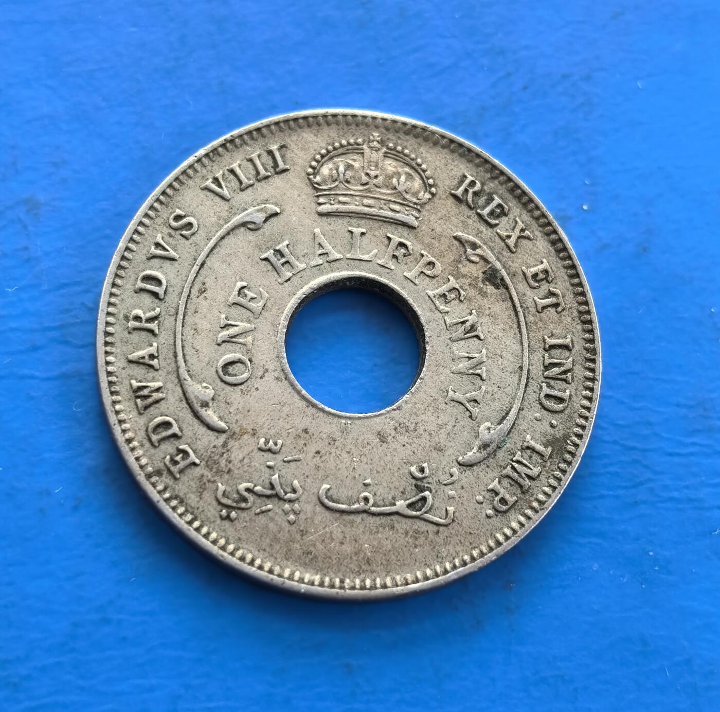 外国优质老铜币高银银币，周六九点倒数截拍，满百包邮，持续收拍 英属西非1936 年半便士H版，诞生于爱德华八世短暂统治（同年退位），见证王室危机与殖民史。中孔设计，正面镌王室铭文及阿拉伯文，背面六芒星分割纪年，融合多元符号。因君主在位极短，成 “过渡政权” 货币标本，历史厚重 + 独特形制，解码英殖民与王室跌宕，是小众收藏的时代切片 。