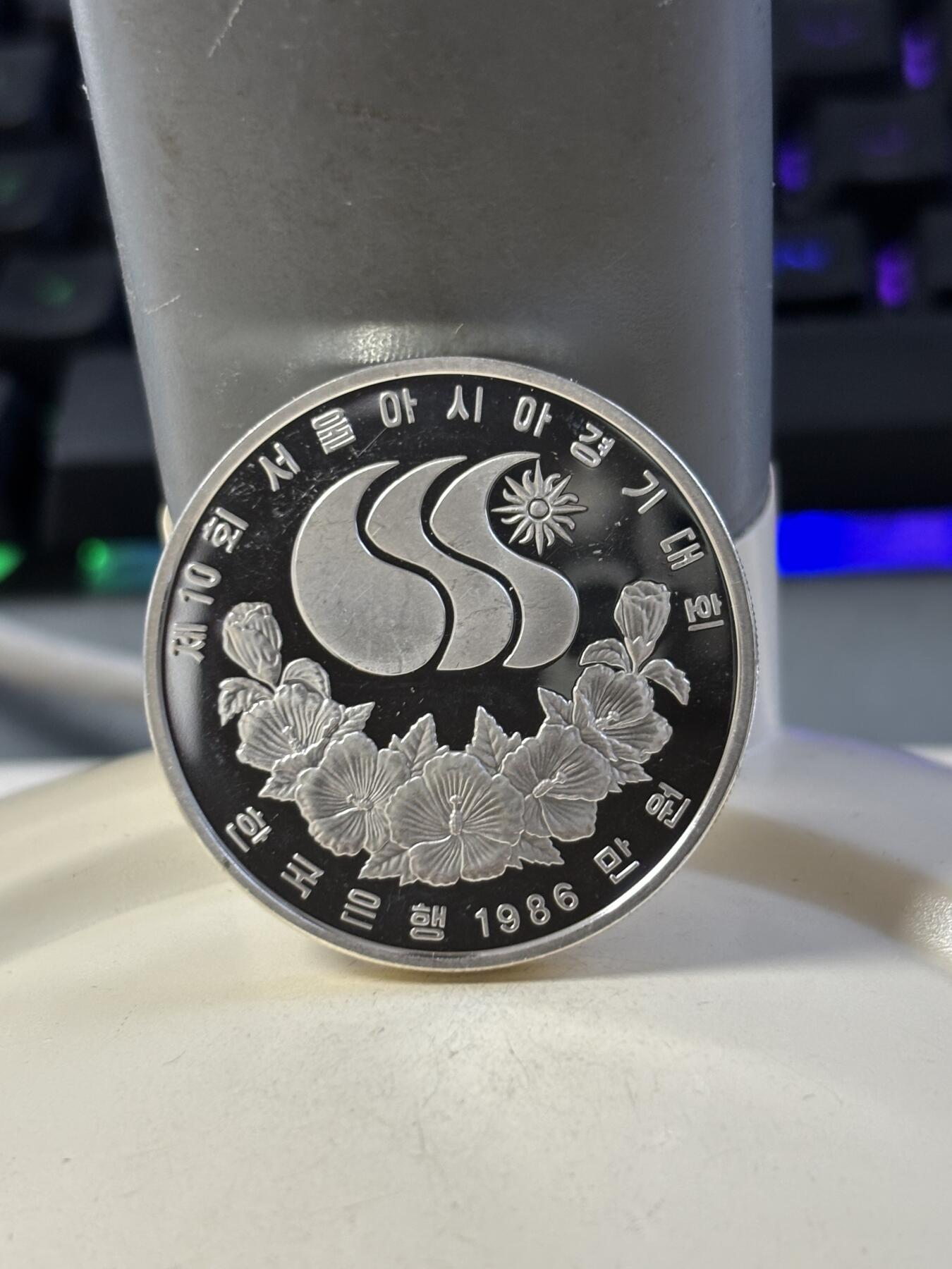 第186期拍卖 韩国1986年第十届亚洲运动会足球纪念银币，900银，23克银价373，有瑕疵，没有塑料盒