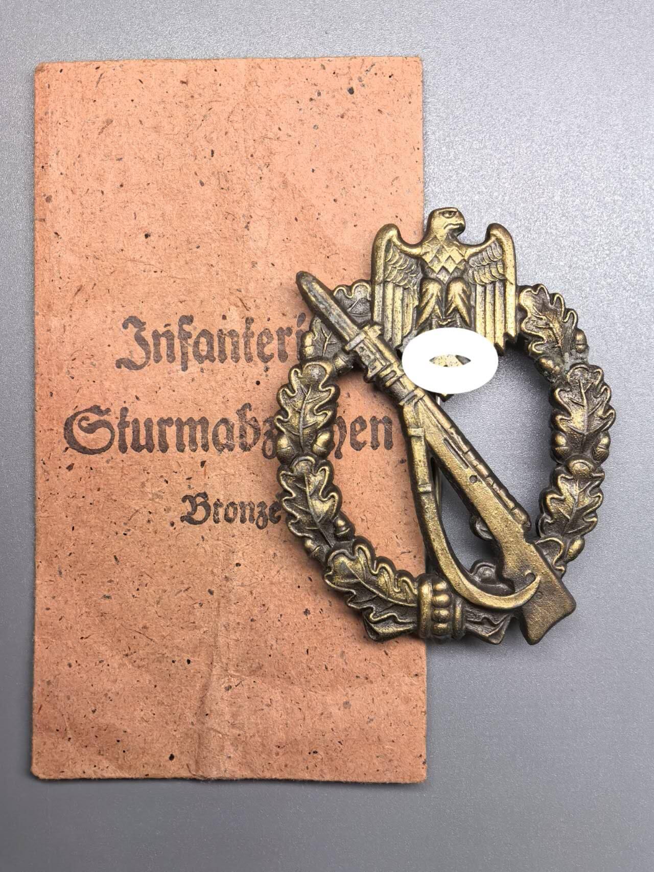 小驴勋章奖章收藏1月2日周五晚六点拍卖（珍爱和平，收藏战争，铭记历史，勿忘国耻，忠党爱国。有偿代拍，送拍规则在简介最后，参拍须阅读规则后再参拍，关系到运费包装发货时效真假辨别等关键信息，拍卖时不再发原图，看大图店主微信码在拍卖店铺介绍里） 德WWII铜级步兵突击奖章，带罕见纸袋，背打JFS标（JOSEF FEIX & SÖHNE-GABLONZ厂，制作很多高品质和带数字战斗章），1.23.2版本，锌合金铸造镀铜，镀层很棒，别杆为Buntmetall合金，少见，参考价550/595欧元不含邮