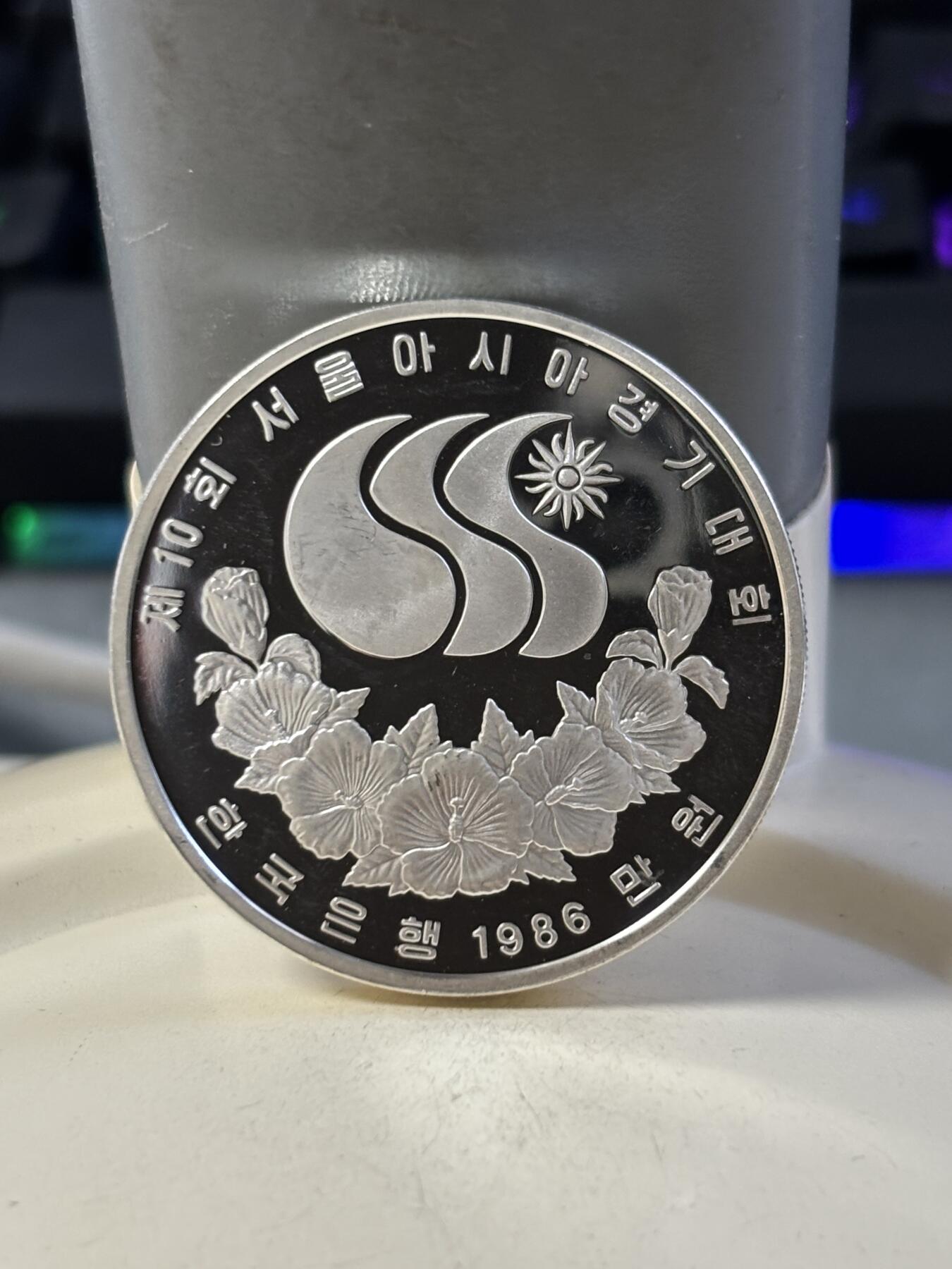 第186期拍卖 韩国1986年第十届亚洲运动会羽毛球纪念银币，900银，23克银价373，有瑕疵，没有塑料盒