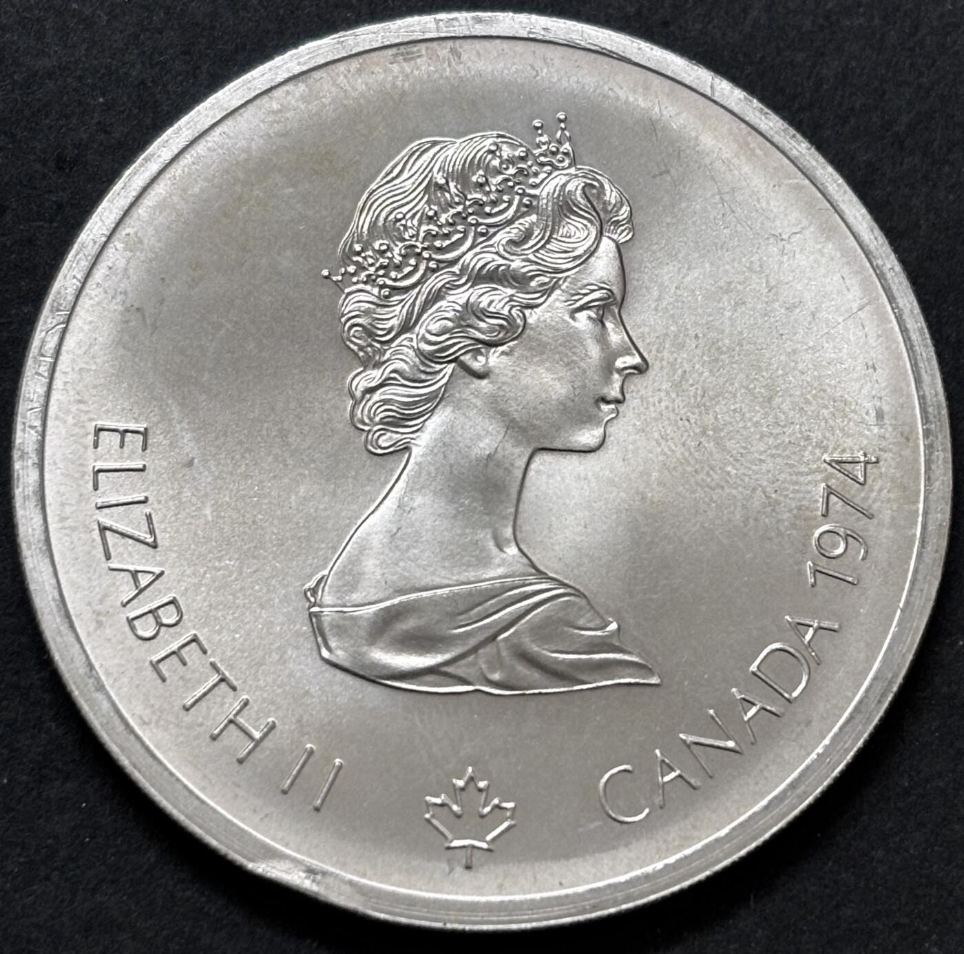 文馨钱币收藏 迎新纳福2026新年第一场（第 287 场）金银老铜币拍卖 原光品相 1974 年加拿大蒙特利尔第 21 届夏季奥林匹克运动会长曲棍球系列 10 元纪念大银币，48.6 克 925 高银，边上有一点小磕碰，品相可评级