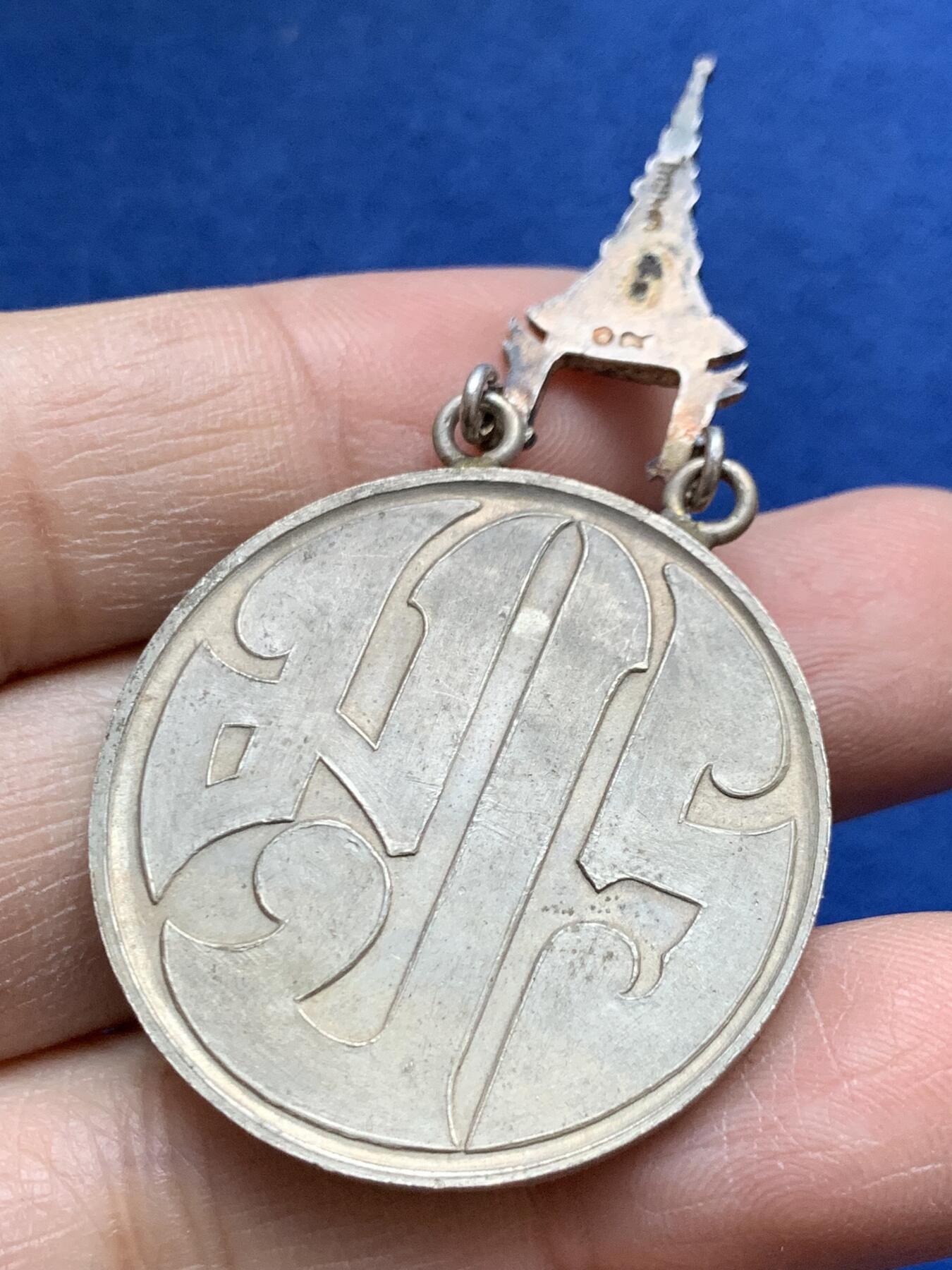 《竞宝斋》第454场 周日，周一 2场连拍 （全场包邮，欢迎送拍） 原盒 泰国银质白象宝塔勋章，历史可以追溯到1861年由当时的君主拉玛四世创立。约上世纪中期发行，佛塔背面有泰文戳记，裸章重约：21.5克。原盒原绶带。这个勋章专门为表彰那些在艺术、科学、商业、外交等领域有杰出贡献的知名人士，状态如图，近未使用品，疑似背面挂环脱落，介意勿拍！