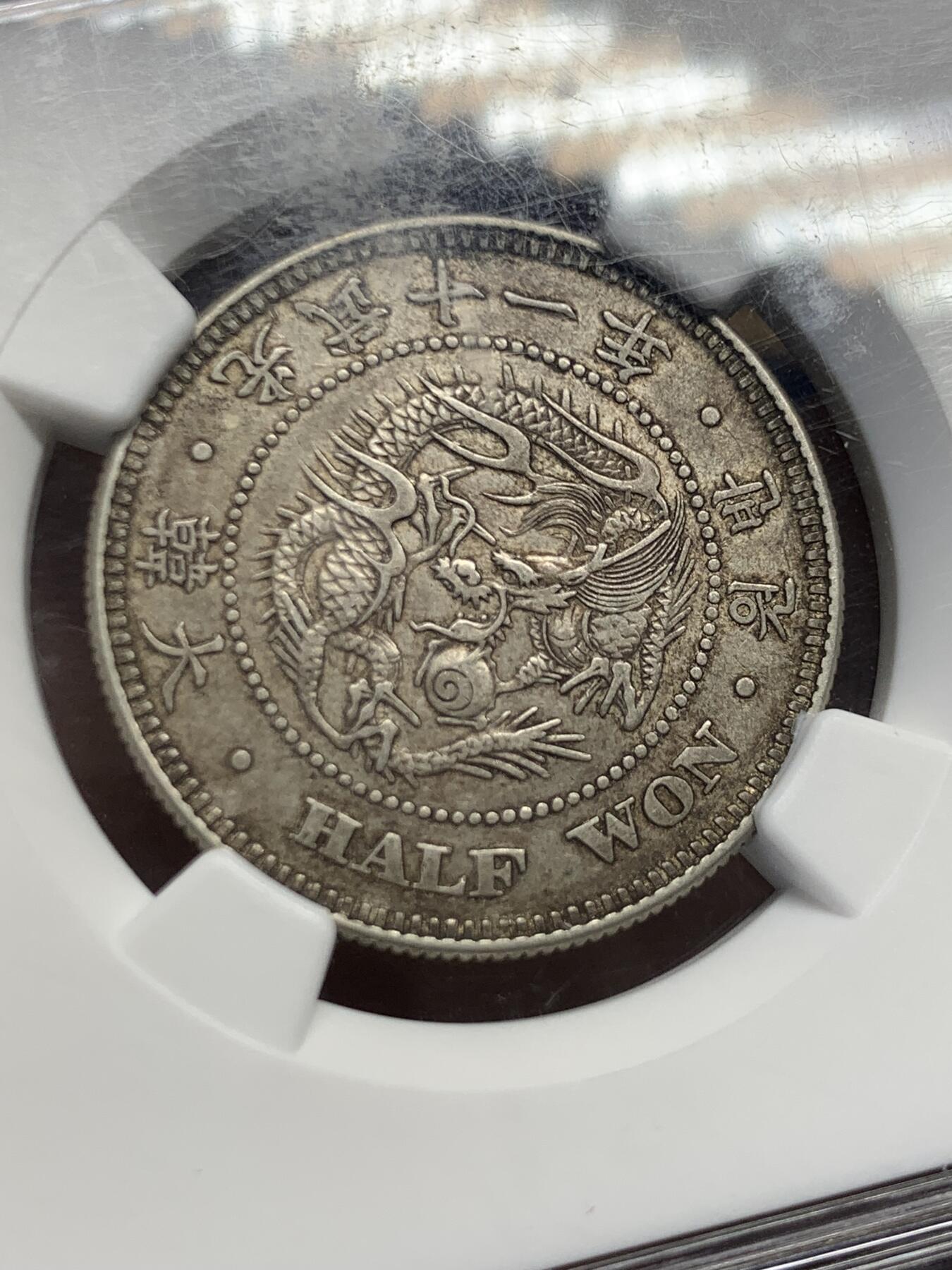 《竞宝斋》第454场 周日，周一 2场连拍 （全场包邮，欢迎送拍） NGC AU58  朝鲜1907年光武十一年半圆 小版稀少年份 百年原味通体自然老彩，正面蟠龙戏珠图，龙身盘踞如环，背面上方为“李花章”（五瓣木槿花），下方交叉的桔梗花（左）与李花（右）