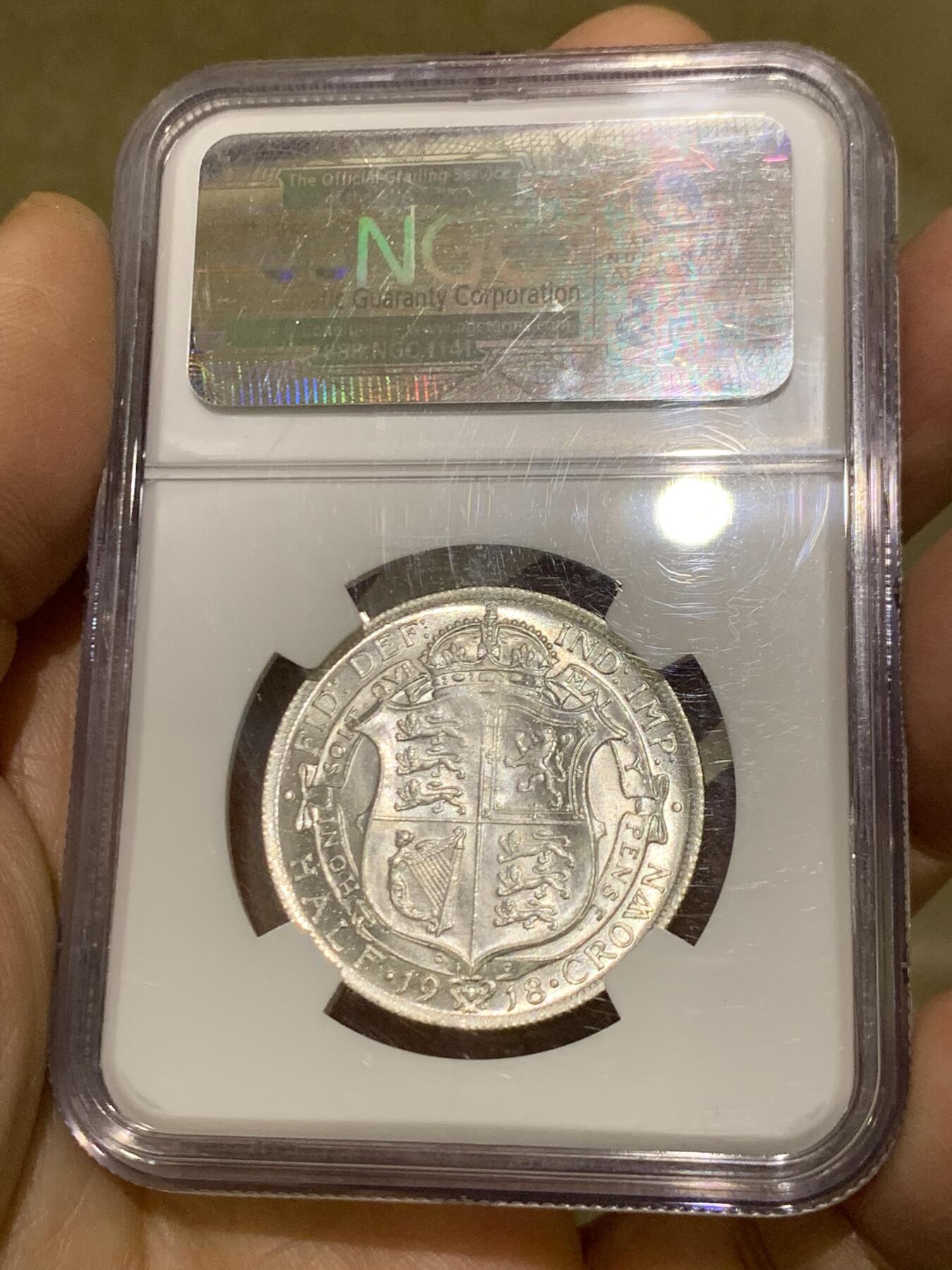 《竞宝斋》第454场 周日，周一 2场连拍 （全场包邮，欢迎送拍） NGC MS64 英国1918年乔治五世1/2克朗银币，乔五早期高银流通版，底板丝滑，银光曜曜，难得高品。此品种发丝常见弱打，此枚发丝胡子细节不错，在同分中也属难得，老盒好状态