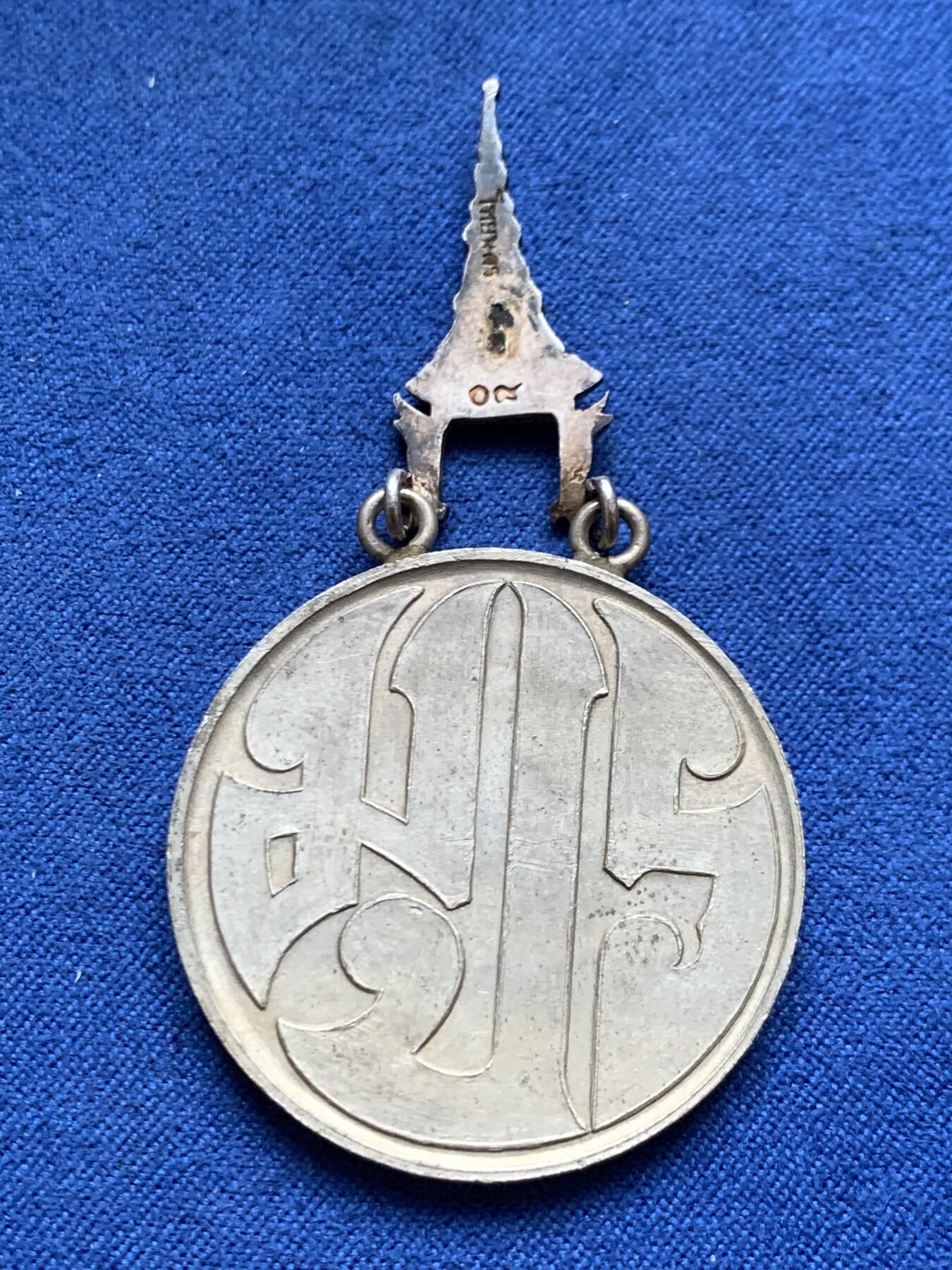 《竞宝斋》第454场 周日，周一 2场连拍 （全场包邮，欢迎送拍） 原盒 泰国银质白象宝塔勋章，历史可以追溯到1861年由当时的君主拉玛四世创立。约上世纪中期发行，佛塔背面有泰文戳记，裸章重约：21.5克。原盒原绶带。这个勋章专门为表彰那些在艺术、科学、商业、外交等领域有杰出贡献的知名人士，状态如图，近未使用品，疑似背面挂环脱落，介意勿拍！