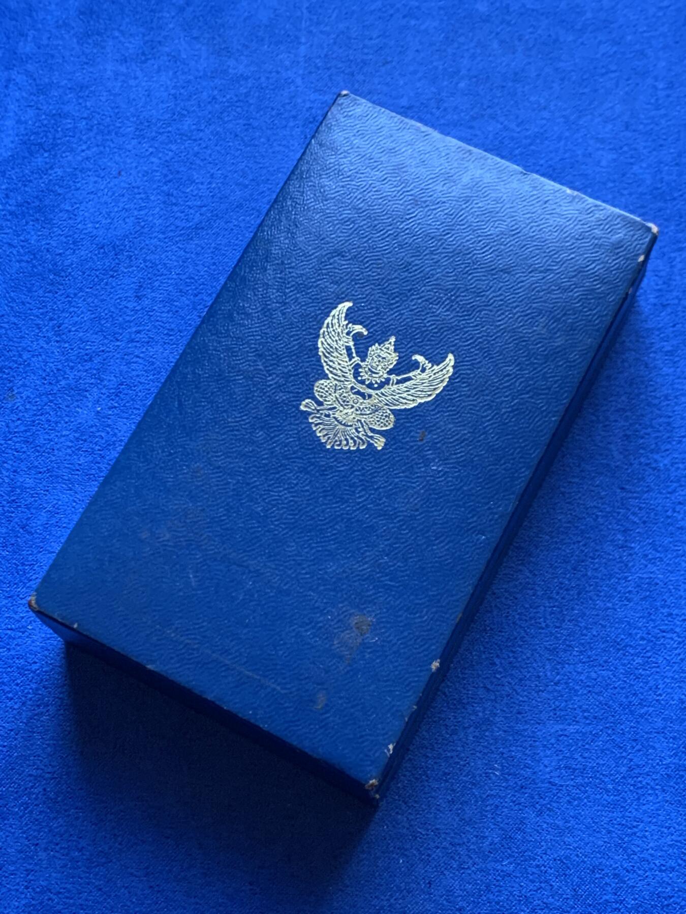 《竞宝斋》第454场 周日，周一 2场连拍 （全场包邮，欢迎送拍） 原盒 泰国银质白象宝塔勋章，历史可以追溯到1861年由当时的君主拉玛四世创立。约上世纪中期发行，佛塔背面有泰文戳记，裸章重约：21.5克。原盒原绶带。这个勋章专门为表彰那些在艺术、科学、商业、外交等领域有杰出贡献的知名人士，状态如图，近未使用品，疑似背面挂环脱落，介意勿拍！