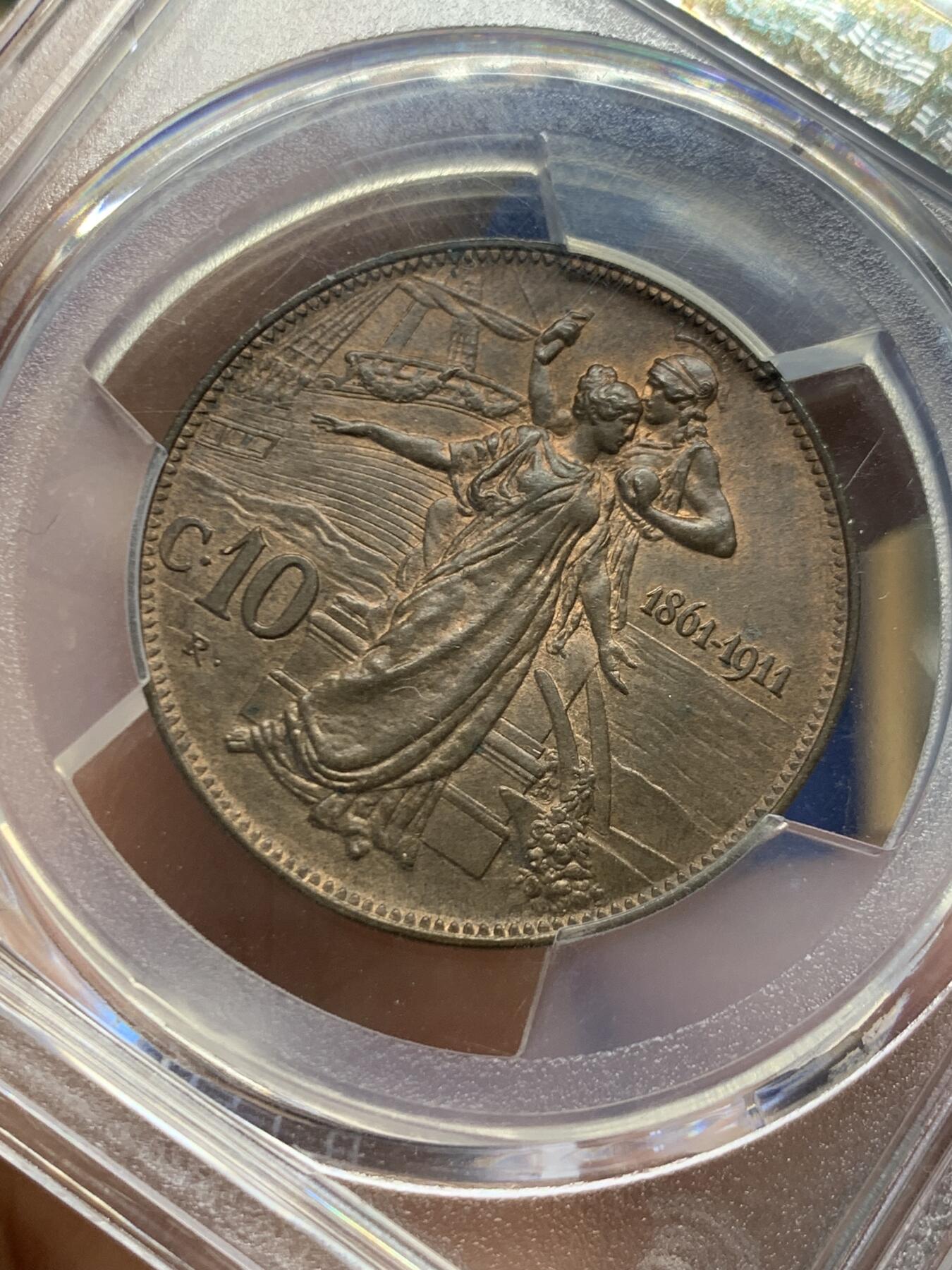 《竞宝斋》第454场 周日，周一 2场连拍 （全场包邮，欢迎送拍） PCGS MS64BN 意大利王国1911年10C铜币，庆祝王国五十周年纪念。正面为国王埃马努埃莱三世，背面为罗马式女神搀扶着此时的意大利女神。原味巧克力包浆，非常漂亮的一枚。