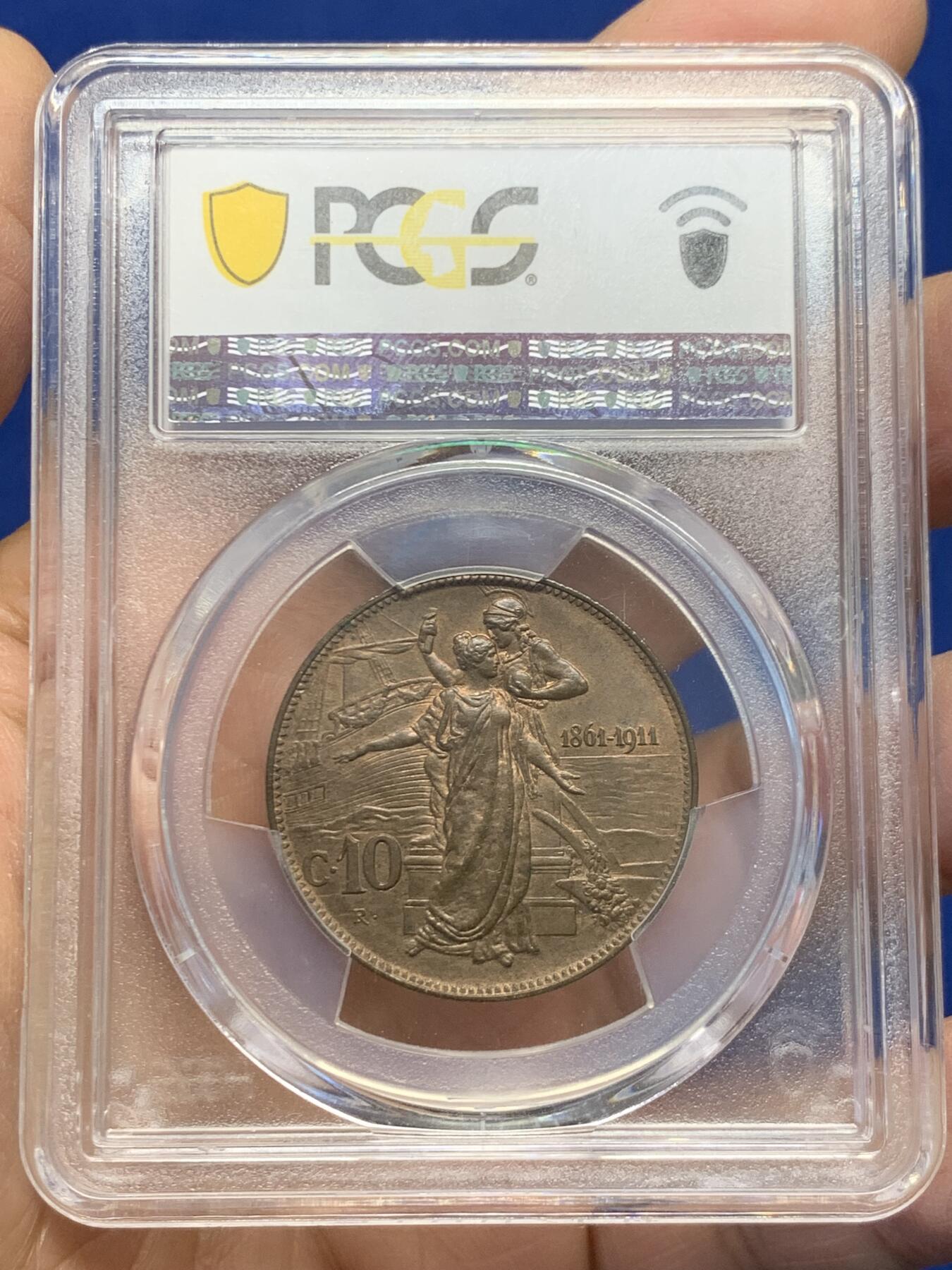 《竞宝斋》第454场 周日，周一 2场连拍 （全场包邮，欢迎送拍） PCGS MS64BN 意大利王国1911年10C铜币，庆祝王国五十周年纪念。正面为国王埃马努埃莱三世，背面为罗马式女神搀扶着此时的意大利女神。原味巧克力包浆，非常漂亮的一枚。