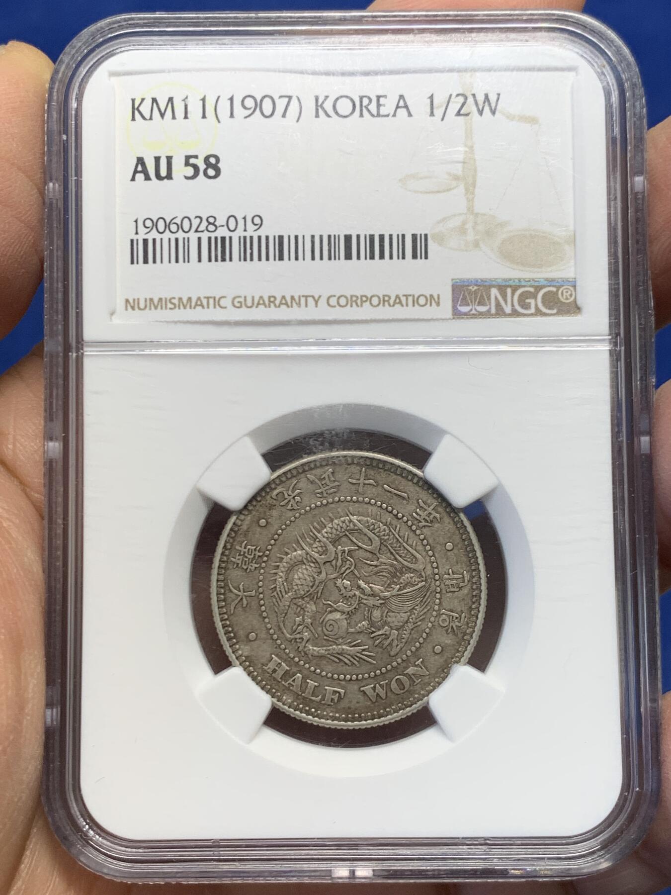 《竞宝斋》第454场 周日，周一 2场连拍 （全场包邮，欢迎送拍） NGC AU58  朝鲜1907年光武十一年半圆 小版稀少年份 百年原味通体自然老彩，正面蟠龙戏珠图，龙身盘踞如环，背面上方为“李花章”（五瓣木槿花），下方交叉的桔梗花（左）与李花（右）