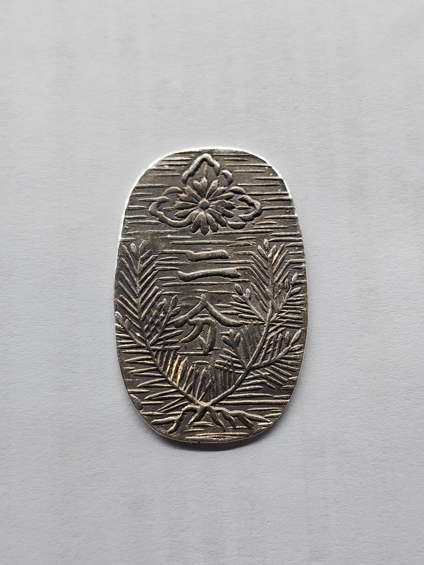 日本回流银判，椭圆形，正面有花纹和“二分”字样，背面有“政”字样，银质，非流通外国钱币，品相以图为准，成色还可以，适合收藏或摆件。