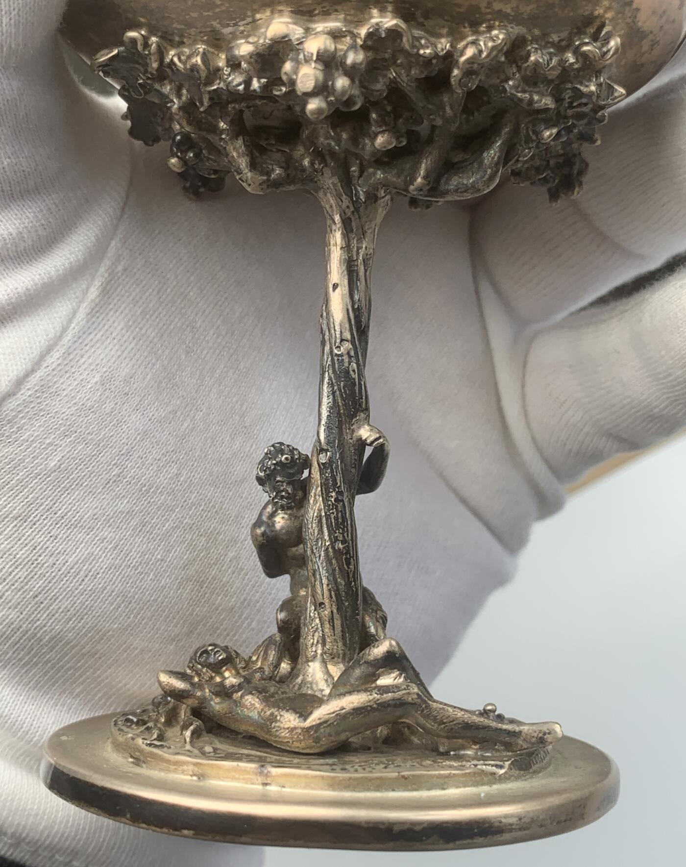 掌中浮雕-藏着的欧洲第048场 意大利潘神银质酒杯。工艺精美，比较少见的立体圆雕杯座和柄座，刻画了半人半羊的潘神与裸女在葡萄树下嬉戏的场景。高度12cm，口径7cm，重量256克，800银戳，底座边缘稍有变形