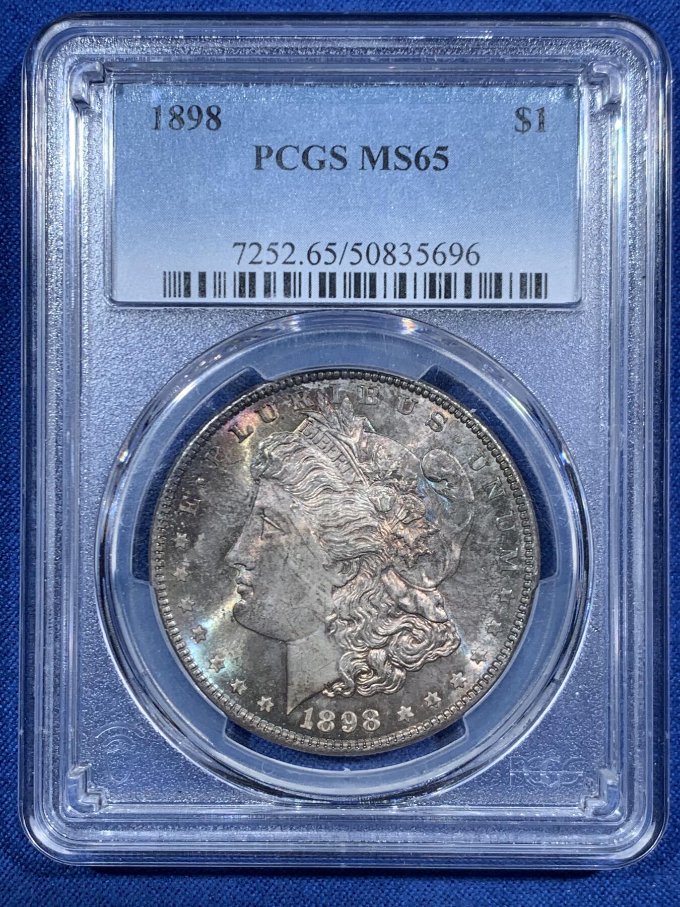 《竞宝斋》第455场 周日，周一 2场连拍 （全场包邮，欢迎送拍） PCGS MS65 美国1898年摩根一美元银币，1898年年份较少，本枚为标准卷首彩，美轮美奂，绚丽五彩，值得重新送评