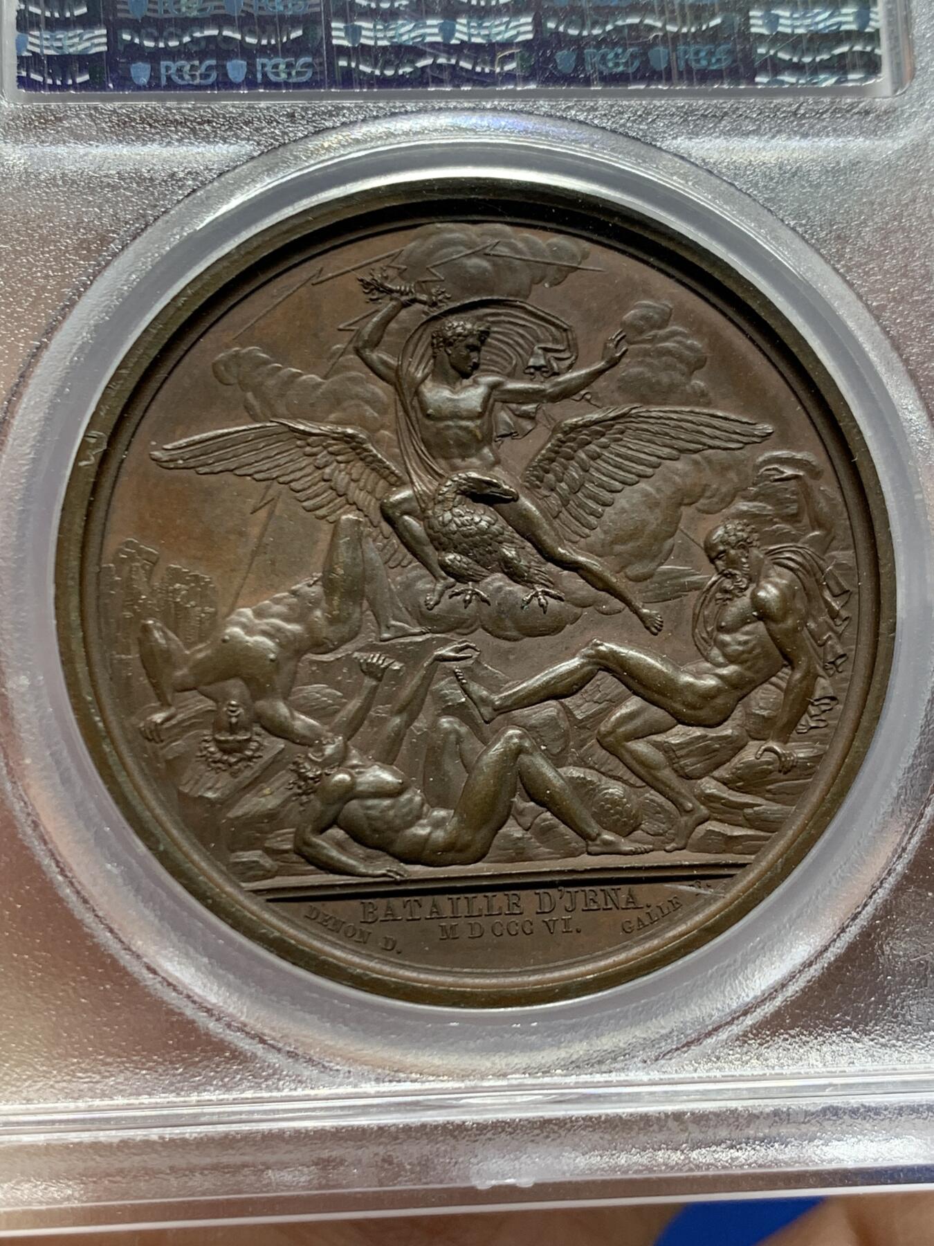 《竞宝斋》第455场 周日，周一 2场连拍 （全场包邮，欢迎送拍） PCGS SP64 法国1806年拿破仑一世耶拿之战原铸铜章 巴黎造币厂 巧克力包浆 拿破仑化身朱庇特（罗马神话中众神之王）身披斗篷骑着帝国之鹰腾云凌空 手持闪电权杖 击倒斩杀地上三名巨人 场面英武壮阔 设计大胆天马行空 肌肉线条精细优美 该战役是拿破仑大破普军经典战役 也是拿章中经典中的经典