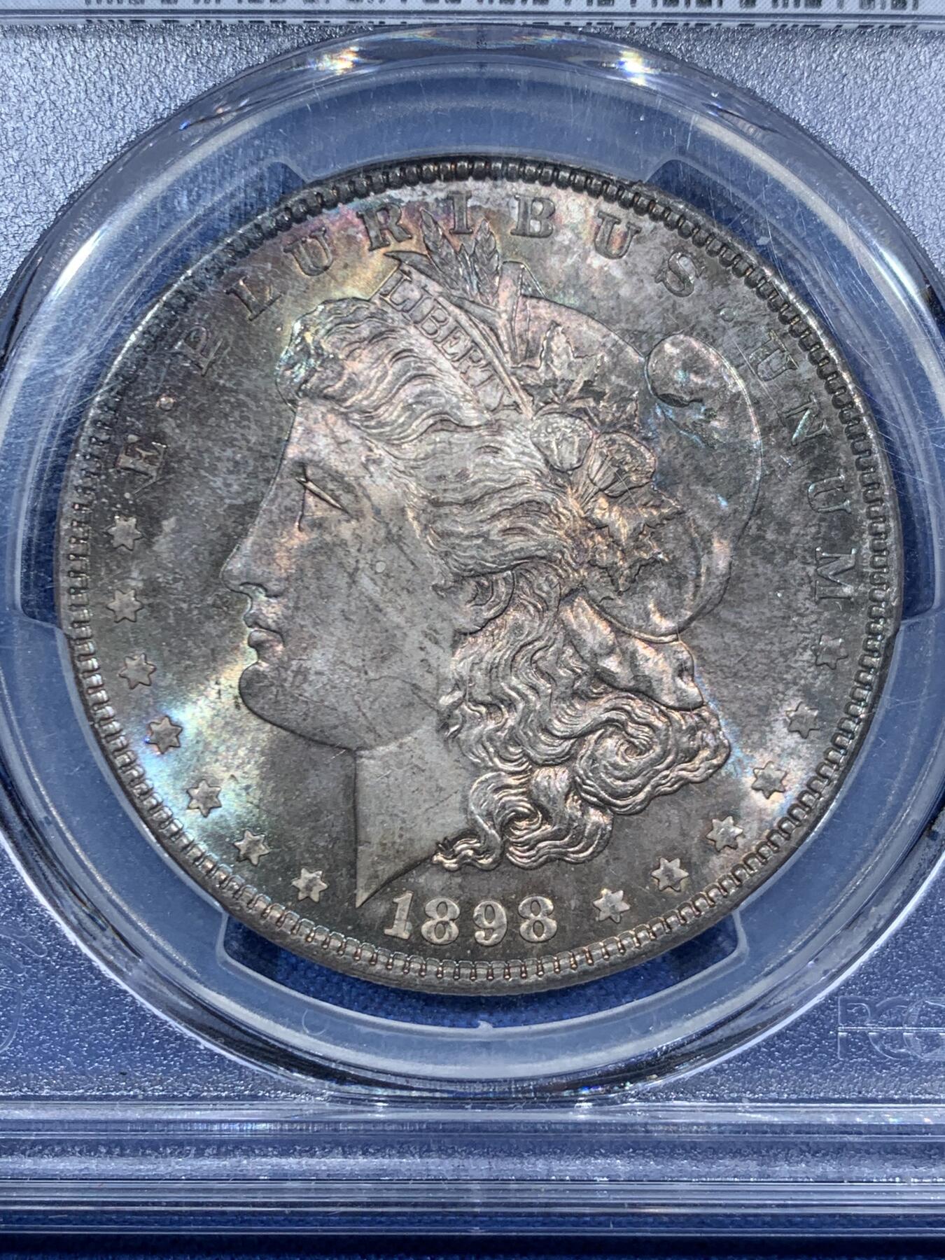 《竞宝斋》第455场 周日，周一 2场连拍 （全场包邮，欢迎送拍） PCGS MS65 美国1898年摩根一美元银币，1898年年份较少，本枚为标准卷首彩，美轮美奂，绚丽五彩，值得重新送评