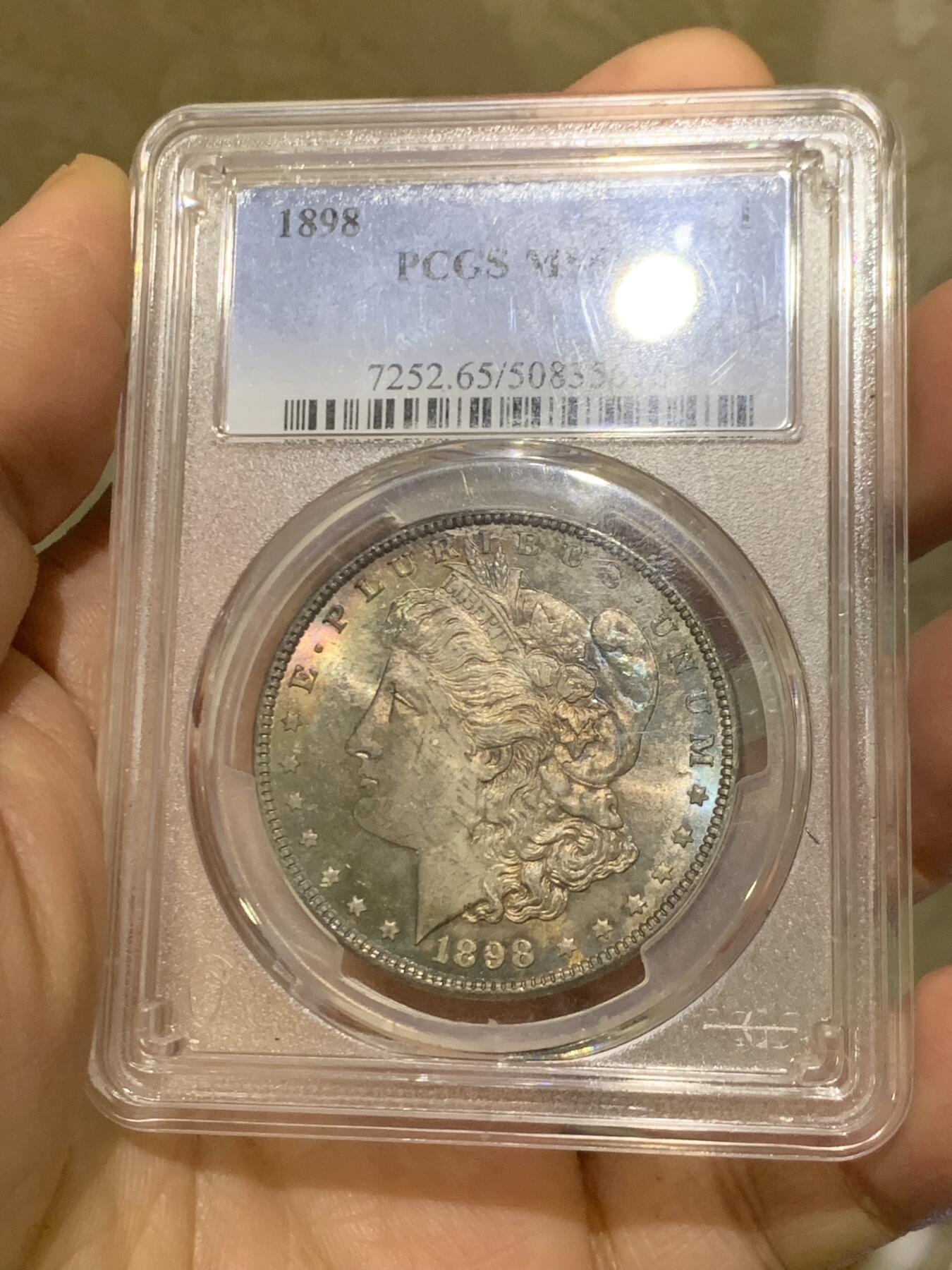 《竞宝斋》第455场 周日，周一 2场连拍 （全场包邮，欢迎送拍） PCGS MS65 美国1898年摩根一美元银币，1898年年份较少，本枚为标准卷首彩，美轮美奂，绚丽五彩，值得重新送评