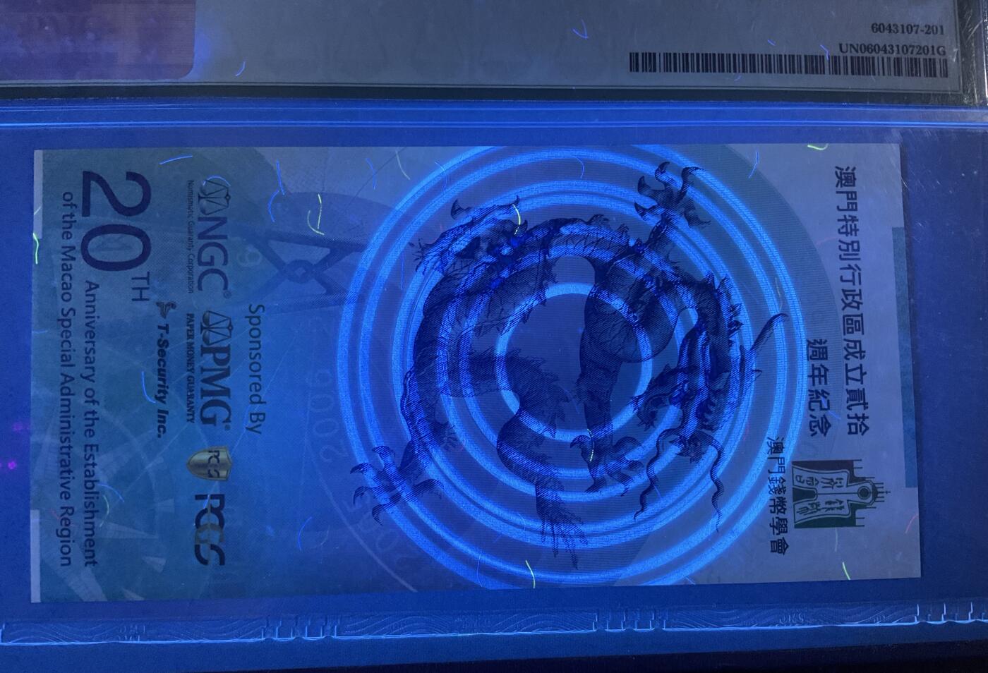 【礼羽收藏】🌏世界钱币拍卖第118期 澳门莲花龙20纪念券钞，钱币学会联合PMG，PCGS，NGC发行，PMG官方封评只有1000均是以UNC封装，正面大三八牌坊地标建筑，反面九龙壁的经典龙。凹凸印多色纤维彩丝荧光靓丽