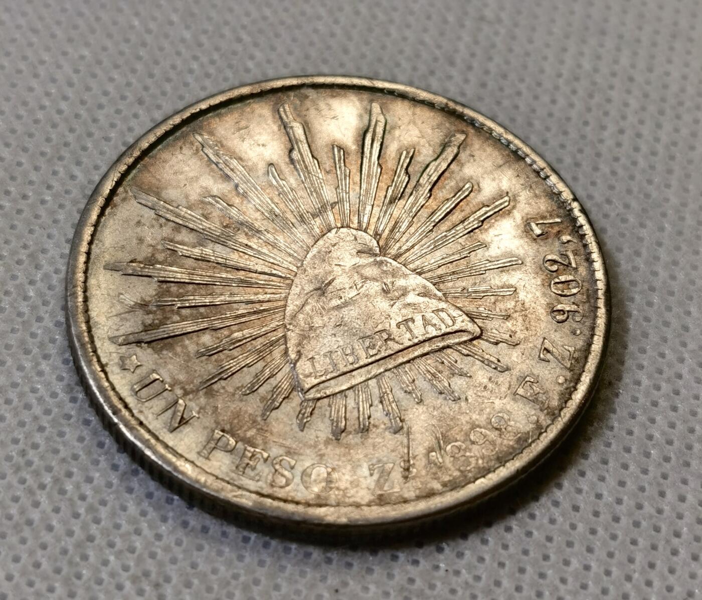 甄臻铺-世界币章拍卖（第46期）送拍享返佣金等优惠多多（1月10日精品场，敬请期待） 墨西哥鹰洋，1898ZS FZ原铸版，此版常见弱打，这枚是少见的全羽毛UNC品相，鹰头和蛇头的表情清晰，对光可看到带有红绿蓝彩色渐变，细节见图