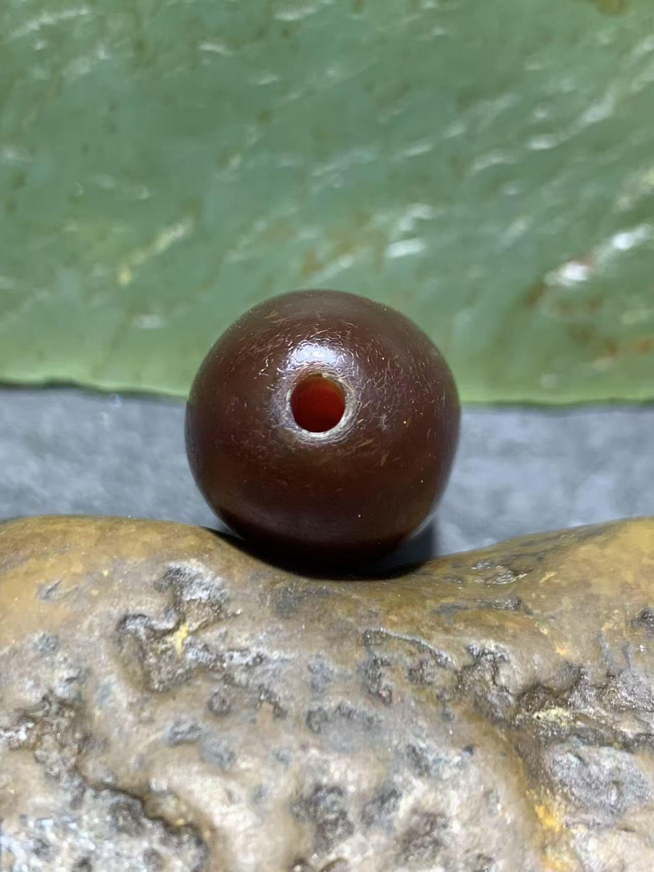 高玉化酒红色玛瑙瑕疵随形桶珠一颗，