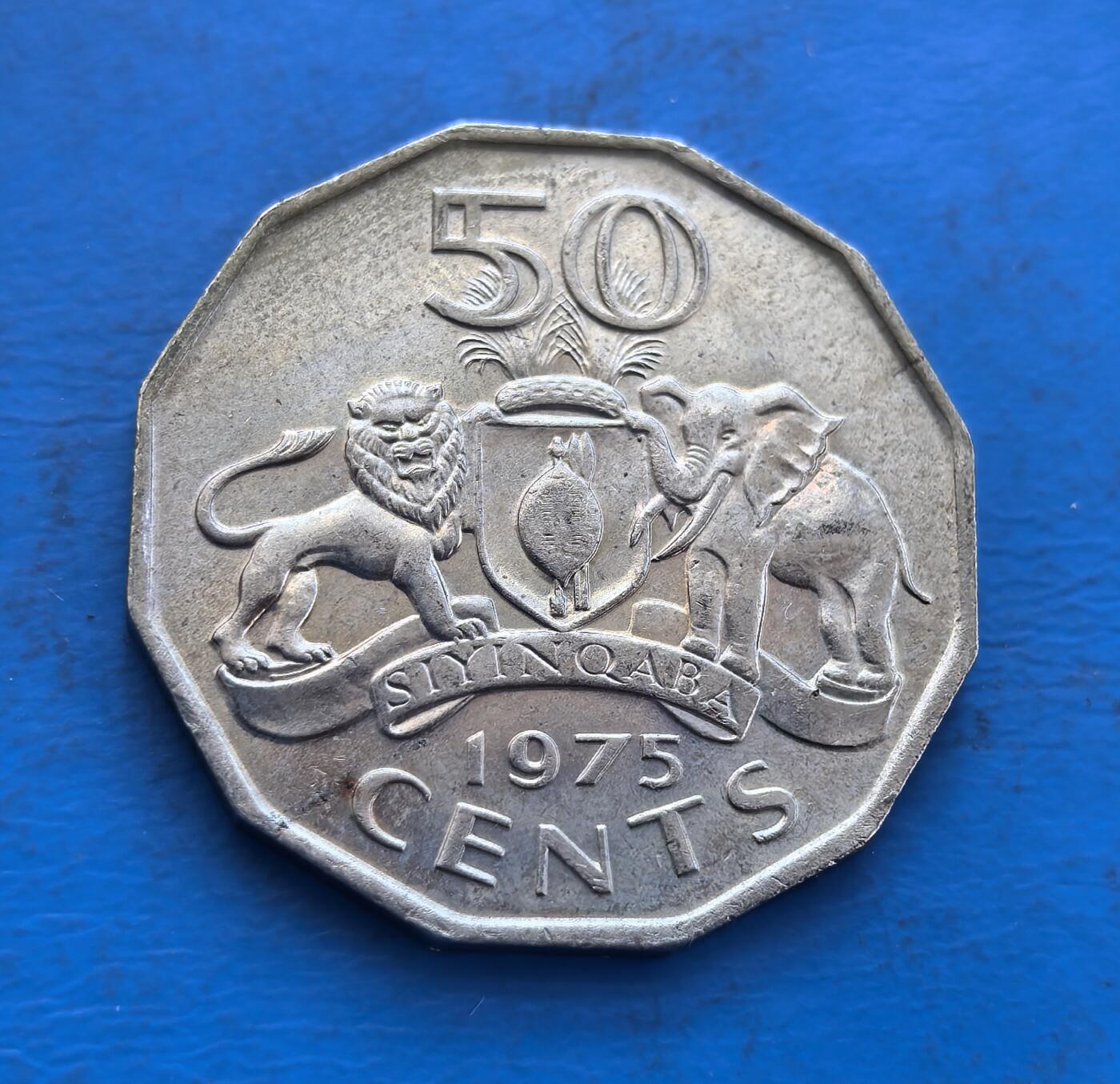 外国优质银币非洲美洲币，周六九点倒数截拍，满百包邮，持续收拍 斯威士兰1975年50 分八角形硬币，正面是国王索布扎二世像（带传统装饰），背面展国徽（狮、象护盾 +“我们是勇士” 标语），风格体现其王室文化与国家标识，是南部非洲特色货币收藏之选。