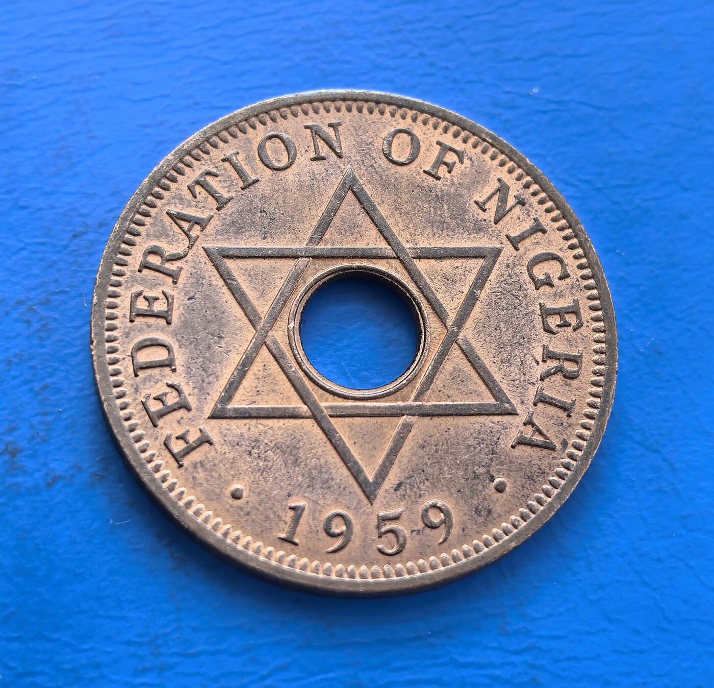 外国优质银币非洲美洲币，周六九点倒数截拍，满百包邮，持续收拍 尼日利亚联邦1959 年 1 便士硬币，带圆孔 + 六角星设计，标英联邦王室标识，属尼日利亚独立前英属货币，风格具殖民联邦特征，是西非英殖币收藏品类。