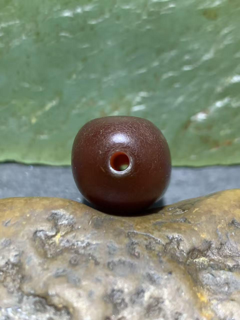 高玉化酒红色玛瑙瑕疵随形桶珠一颗，