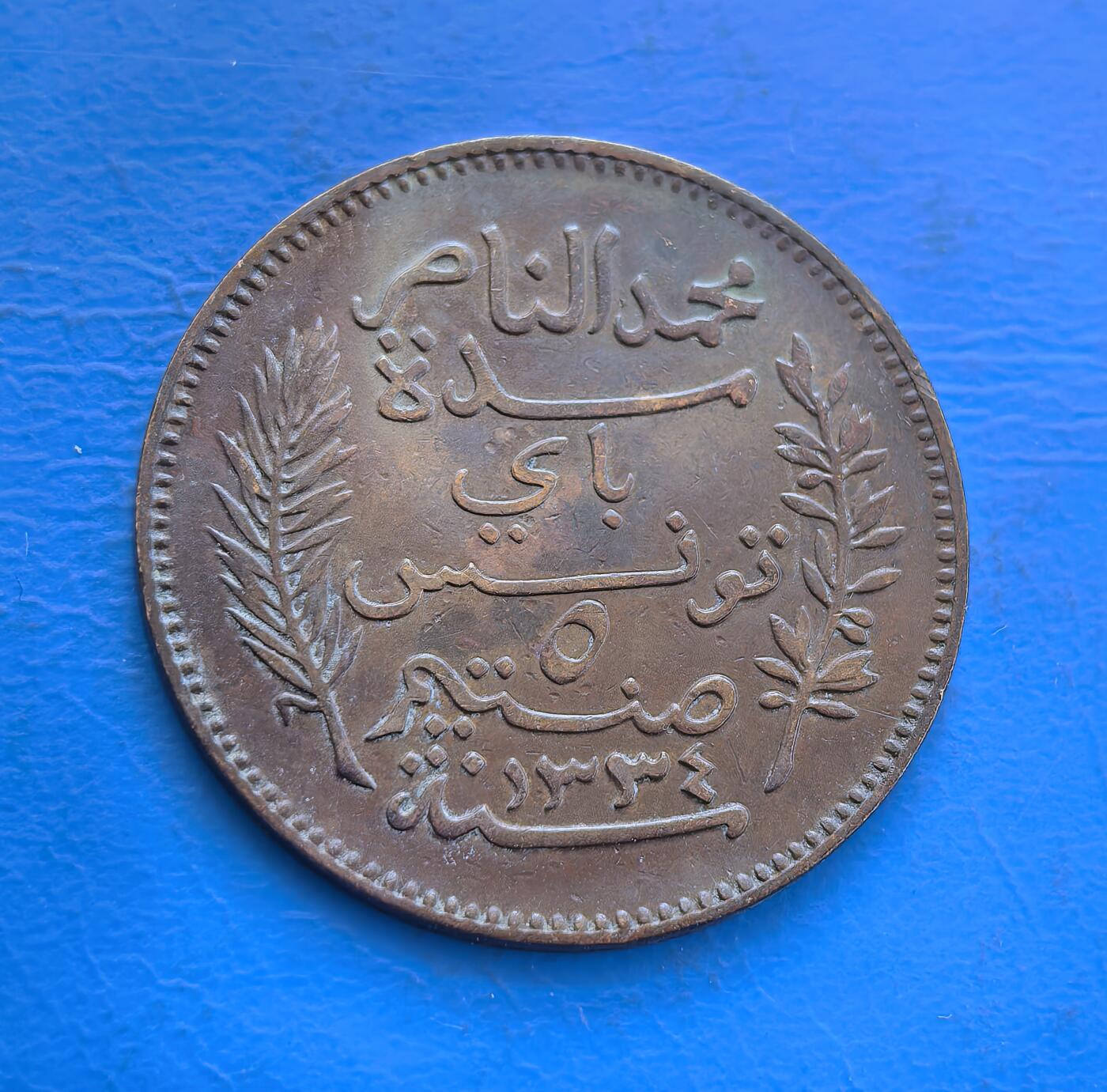 外国优质银币非洲美洲币，周六九点倒数截拍，满百包邮，持续收拍 极美品突尼斯1916 年 5 分殖民铜币，正面标 “TUNISIE” 及年份，背面饰阿拉伯文与棕榈枝，属北非殖民时期流通币，风格融合法殖与本土元素，具历史货币收藏价值。