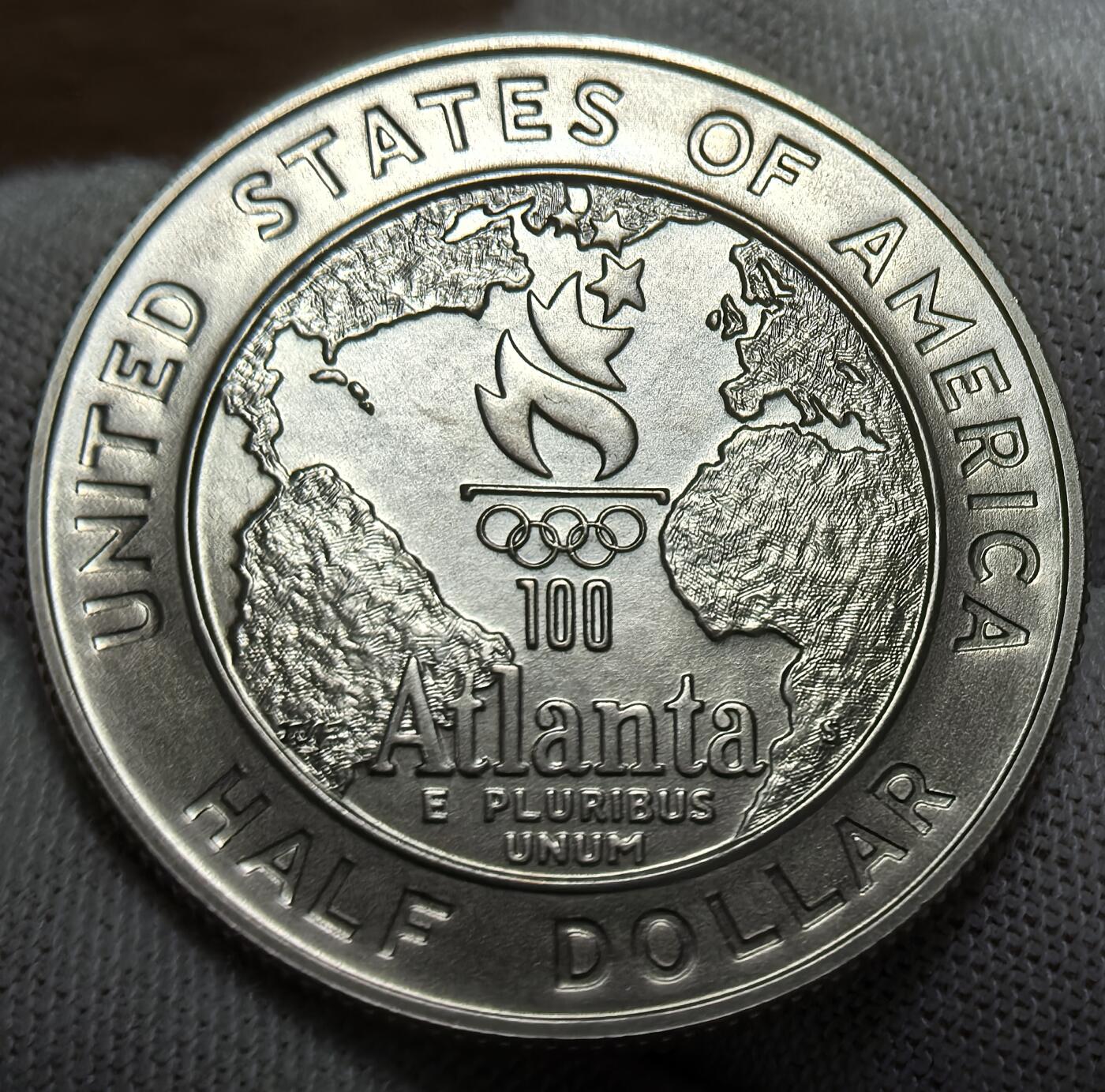 外国优质银币非洲美洲币，周六九点倒数截拍，满百包邮，持续收拍 稀少美国1995 年亚特兰大奥运半美元，正面绘棒球竞技场景，背面展奥运火炬与世界地图，关联百年奥运赛事，精制币细节生动，具体育纪念与收藏价值。