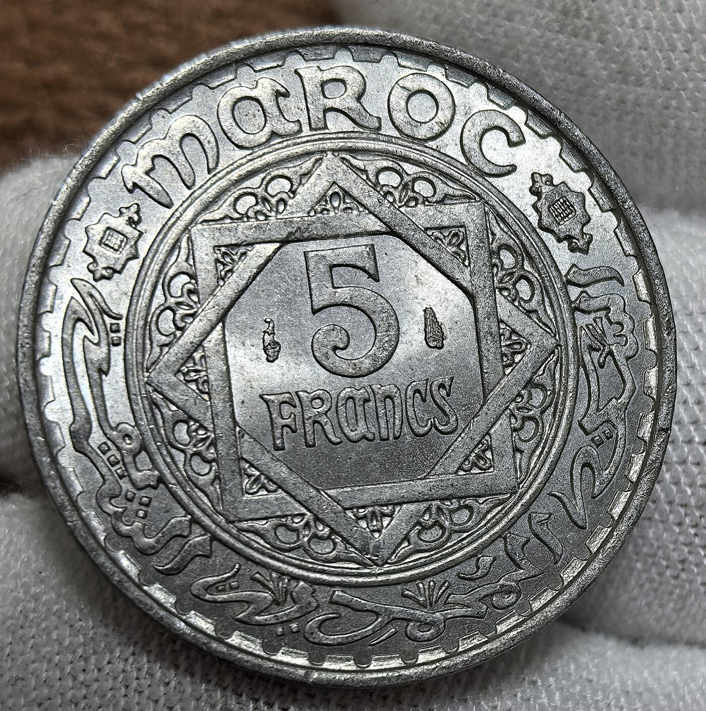 外国优质银币非洲美洲币，周六九点倒数截拍，满百包邮，持续收拍 极美品原光摩洛哥（谢里夫帝国时期）1950年5 法郎硬币，币面融伊斯兰几何纹饰与阿拉伯文，风格体现北非伊斯兰文化，属摩洛哥近代货币，具地域文化与历史货币收藏价值。